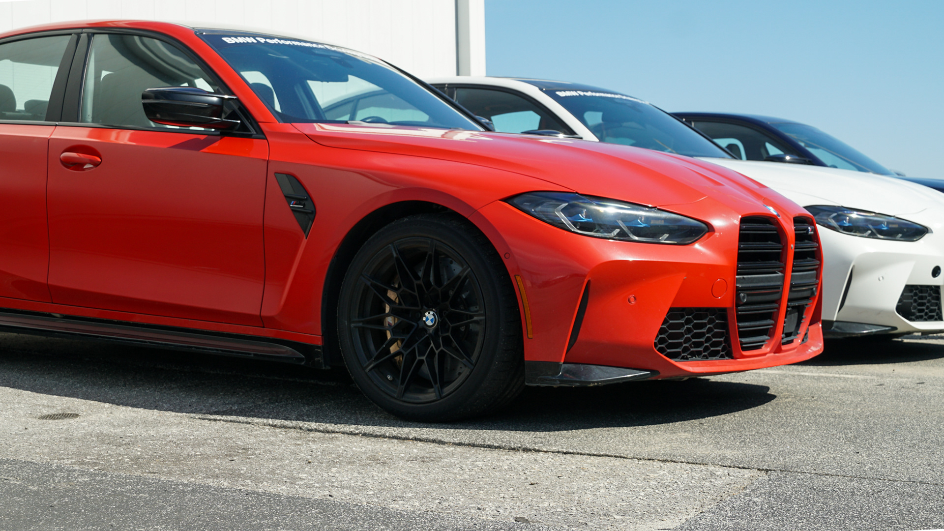 2021 BMW M3 Competitions Description: Three/fourths view of two BMW M3's parked at the BMW Performance Center in Greer, South Carolina.