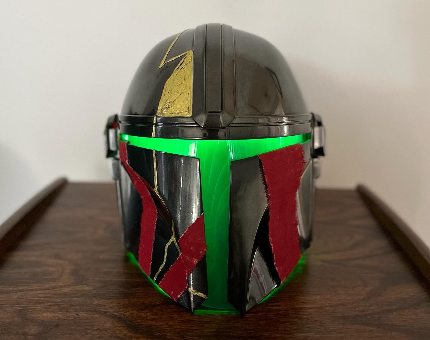Resin cast Mandalorian helmet. Finished with gold paint pen, dyed wraps, and LEDs. Resin cast from JPF Props. Jul 2023.