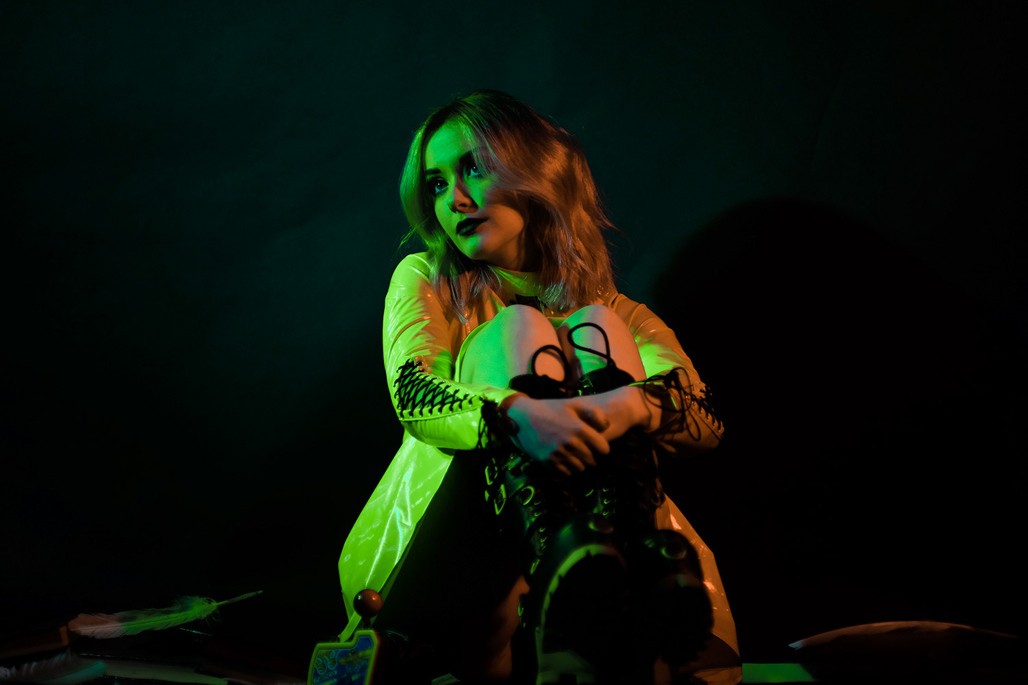 Vocalist Emma Shippen sat in green dress and chunky boots, looking upwards