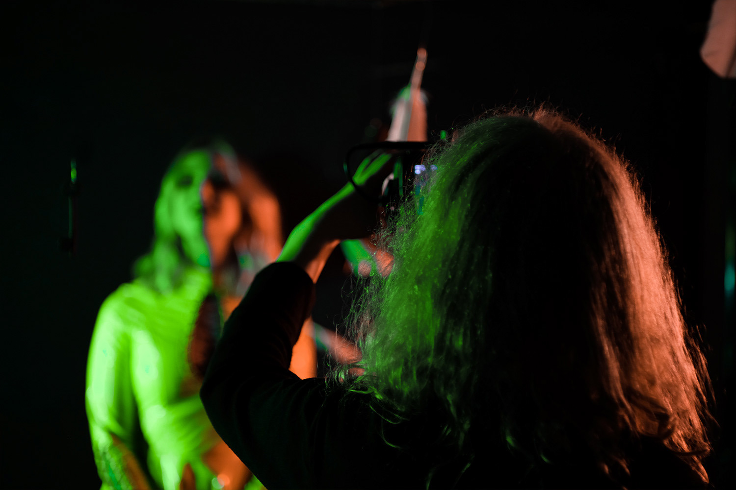 Guitarist David Dyson shot from behind, filming Emma Shippen