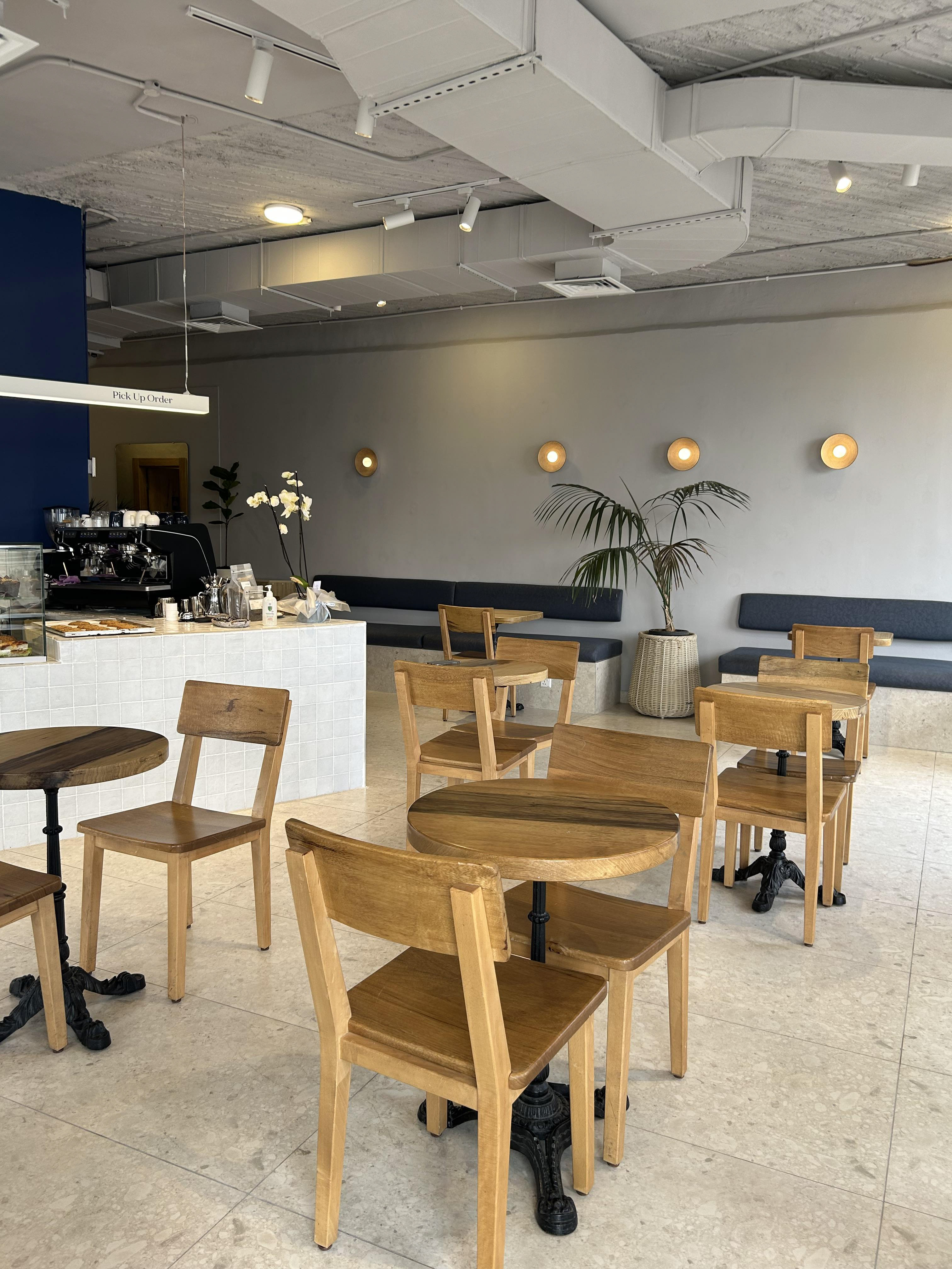 Azul bakery and coffee house interior design in Amman Jordan. Exposed ceiling, modern, minimalist, plants, wood.
