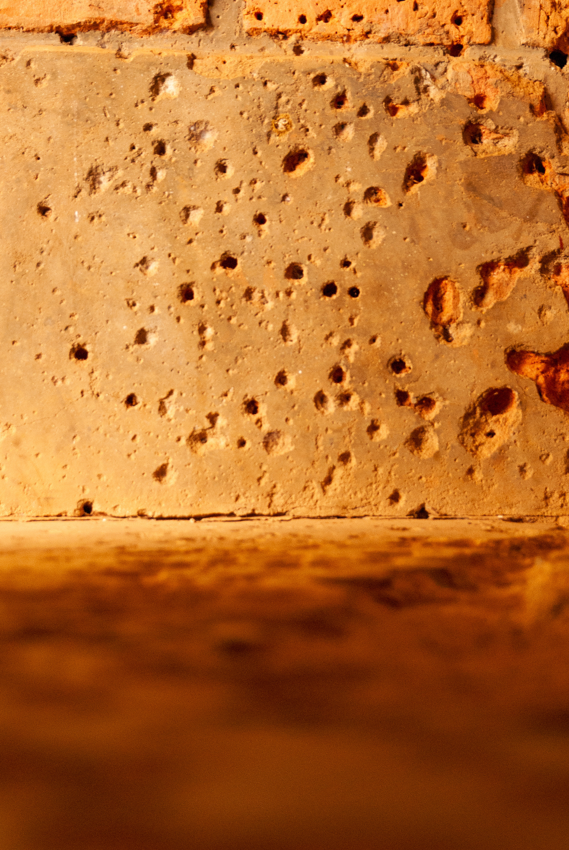 A wall peppered with bullet holes - the site on which many people fleeing to the safety of a church died. Nyamata, Rwanda