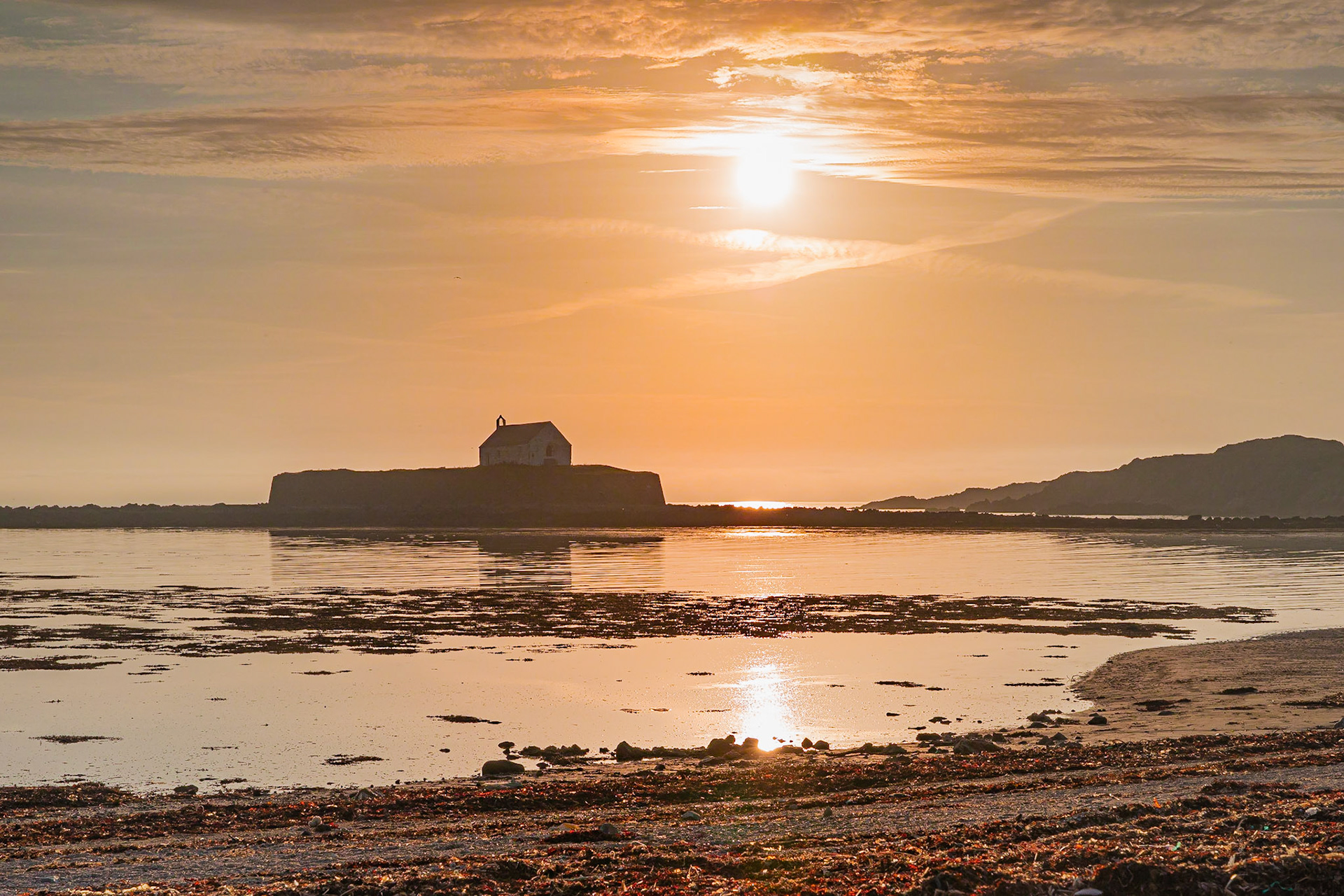 The Church of St. Cwyfan bathed in the pastel colours of a late evening.