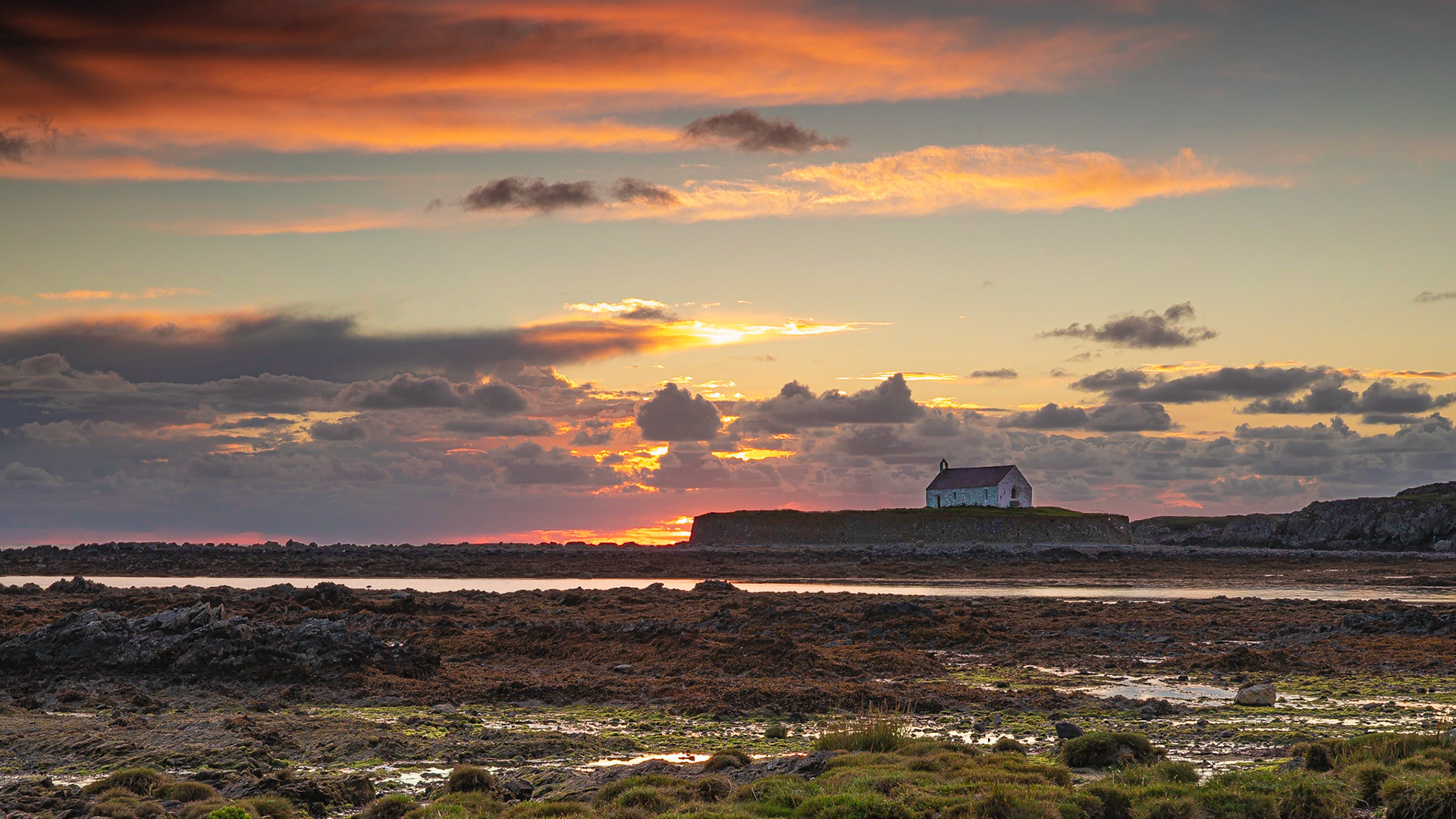 Sunset at Porth Cwyfan against an ominous sky.