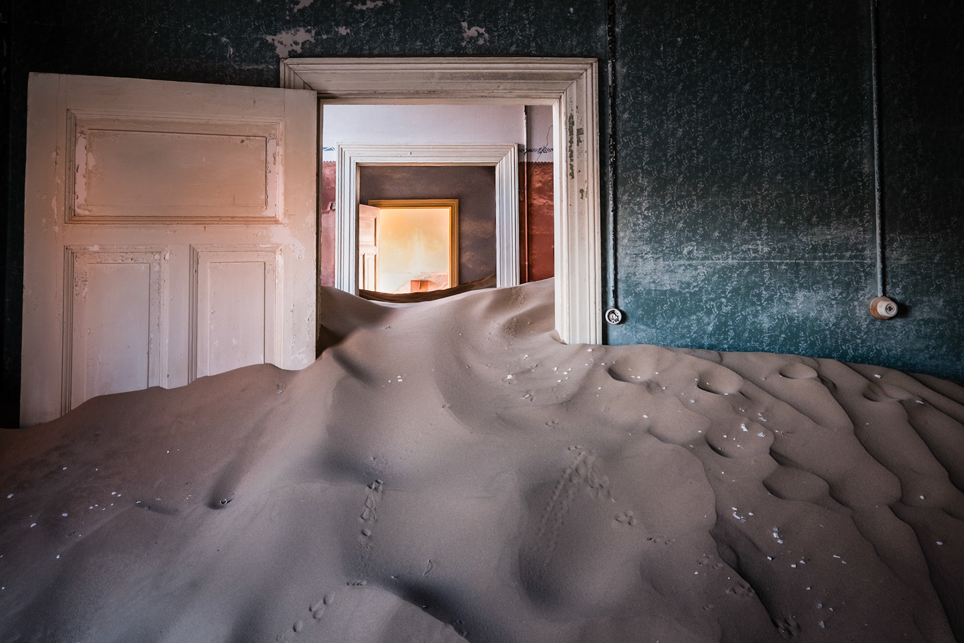 Kolmanskop was the first mining town built in the Namib after diamonds were discovered in 1908.  Water had to be trucked in from 60 miles away, there were high winds day and night with sand everywhere.  The town survived until 1943.