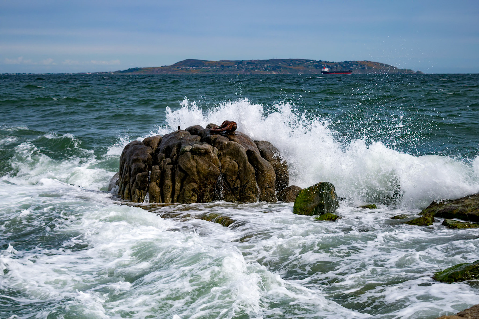 Sunlit waters and shifting tides along the historic stone walls of Bullock Harbour, framed by the open expanse of Dublin Bay.