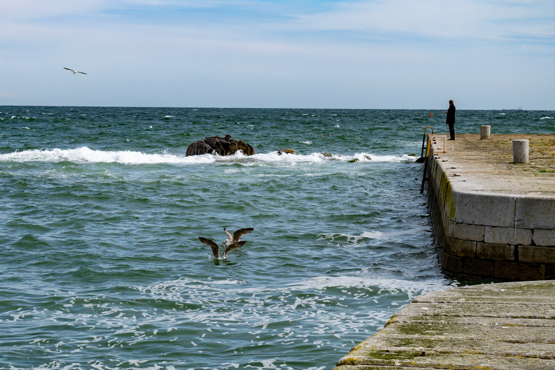 Sunlit waters and shifting tides along the historic stone walls of Bullock Harbour, framed by the open expanse of Dublin Bay.