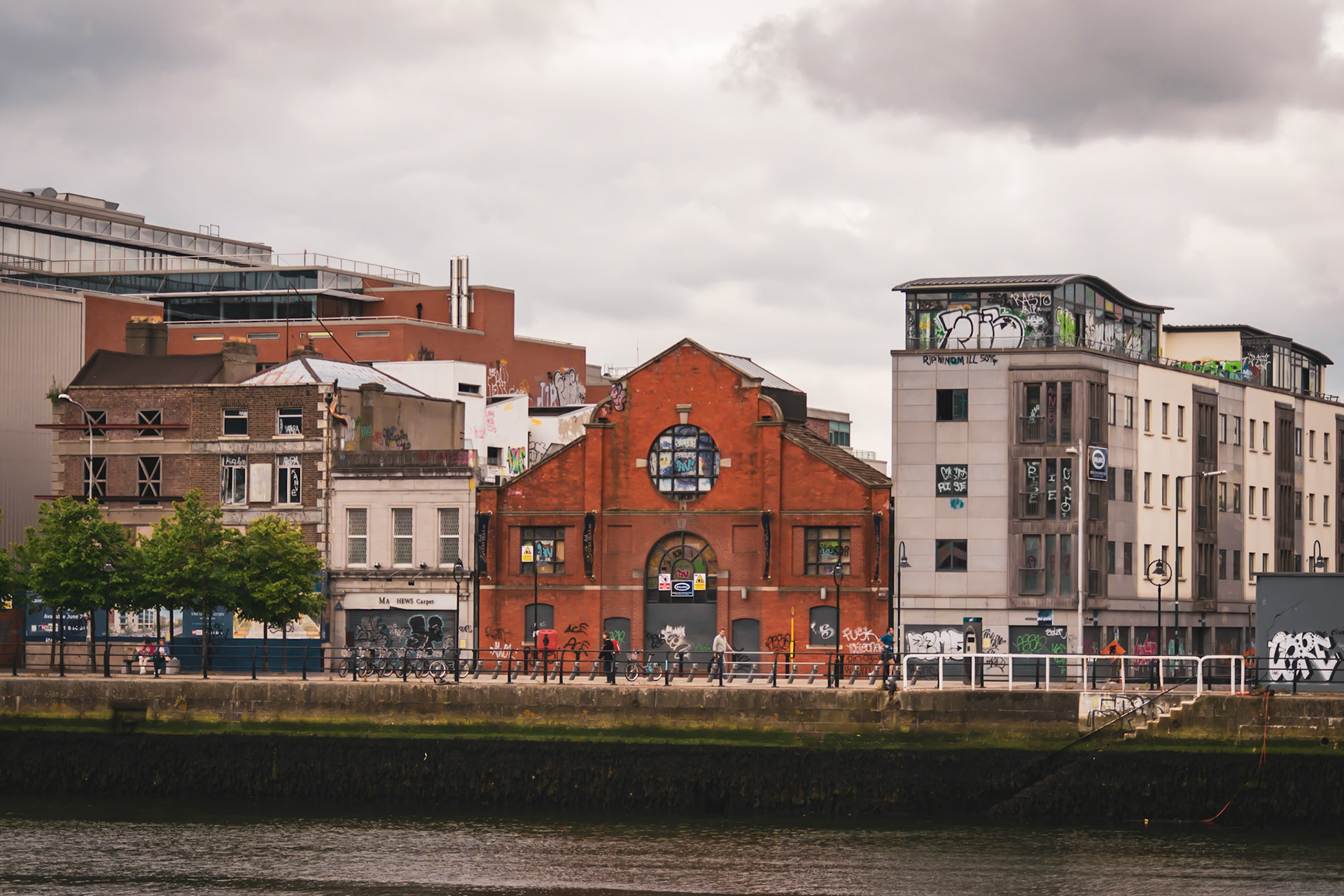A visual look at Dublin’s maritime history, where the wooden masts and rigging of a famine ship replica stand against the modern city skyline.