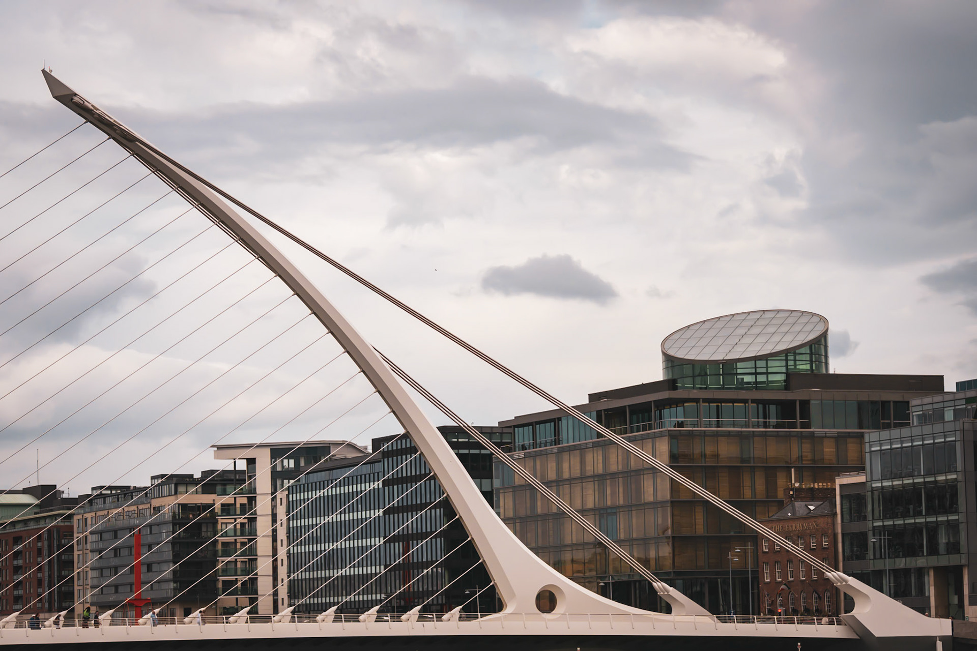 A visual look at Dublin’s maritime history, where the wooden masts and rigging of a famine ship replica stand against the modern city skyline.