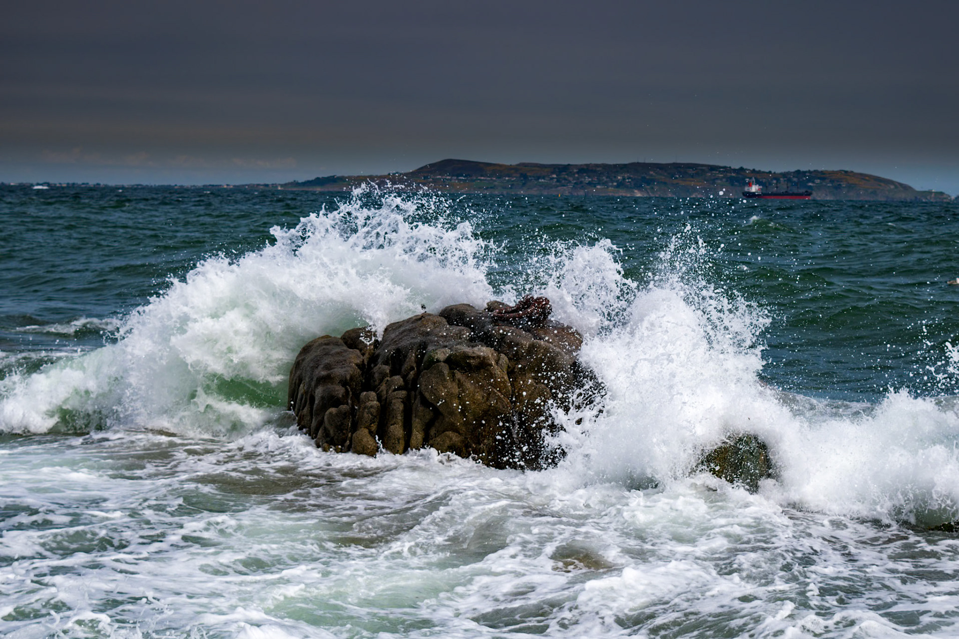 Sunlit waters and shifting tides along the historic stone walls of Bullock Harbour, framed by the open expanse of Dublin Bay.