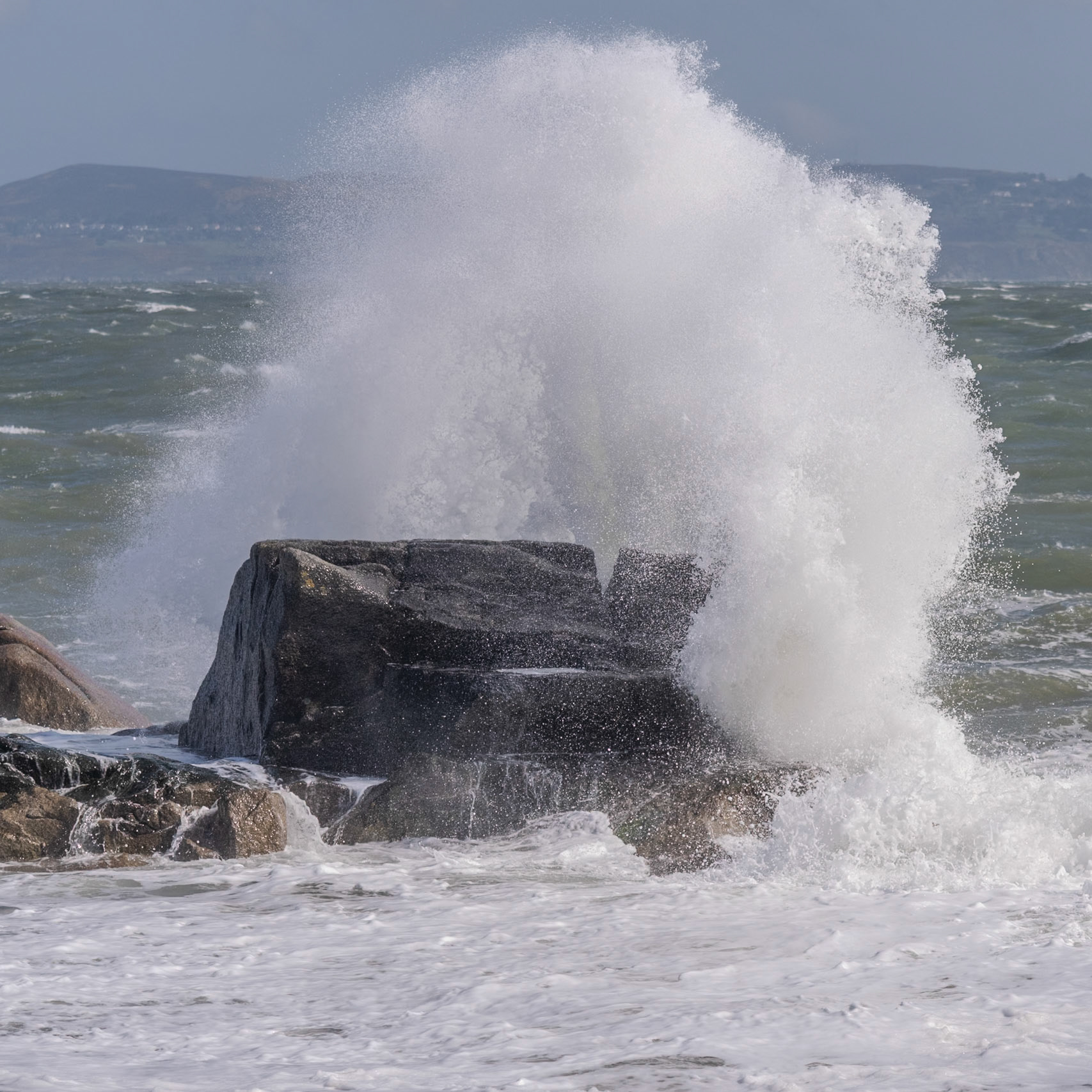 A study in contrast and chaos—where the relentless rhythm of the tide meets the immovable granite of the Dublin coast.