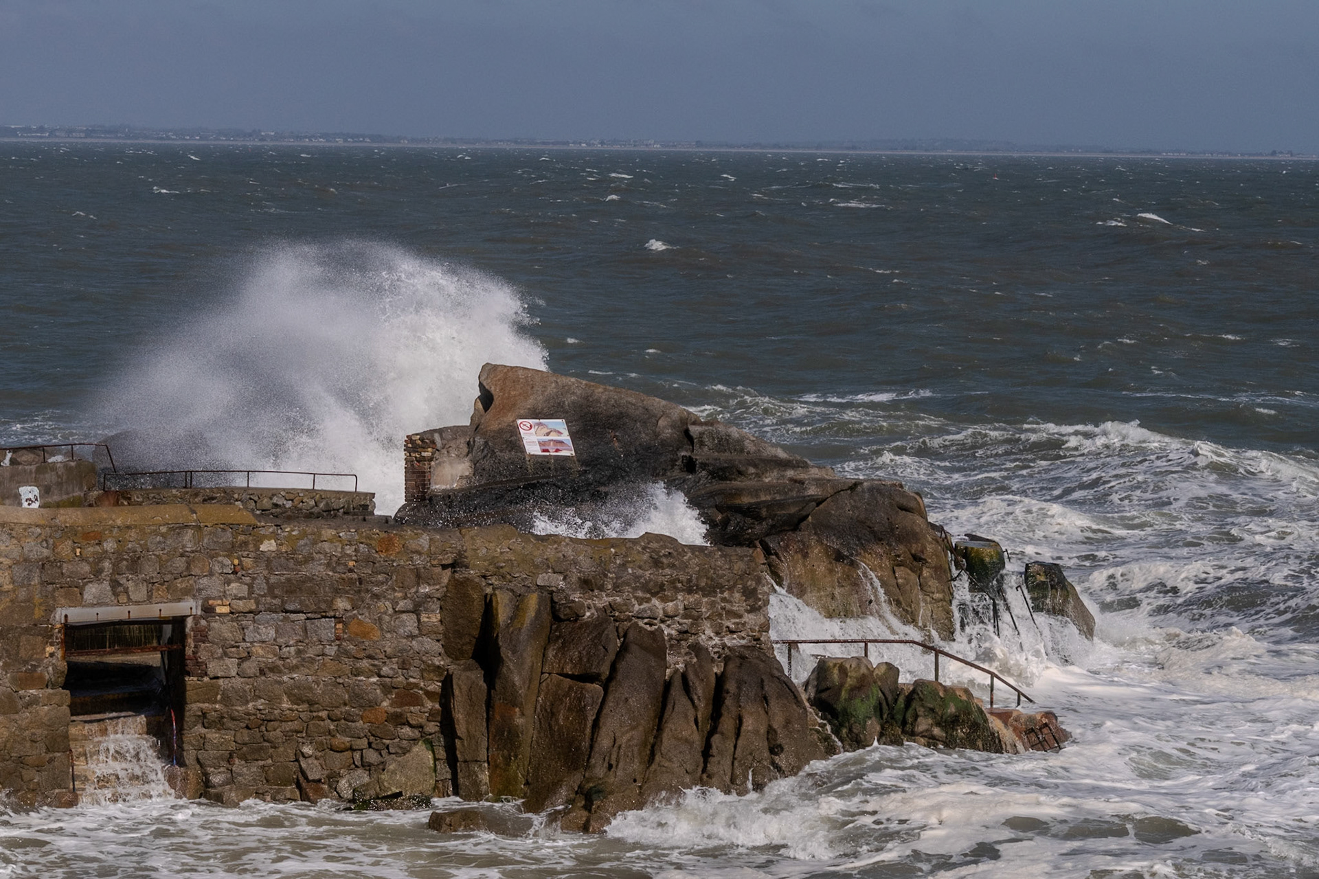 A study in contrast and chaos—where the relentless rhythm of the tide meets the immovable granite of the Dublin coast.