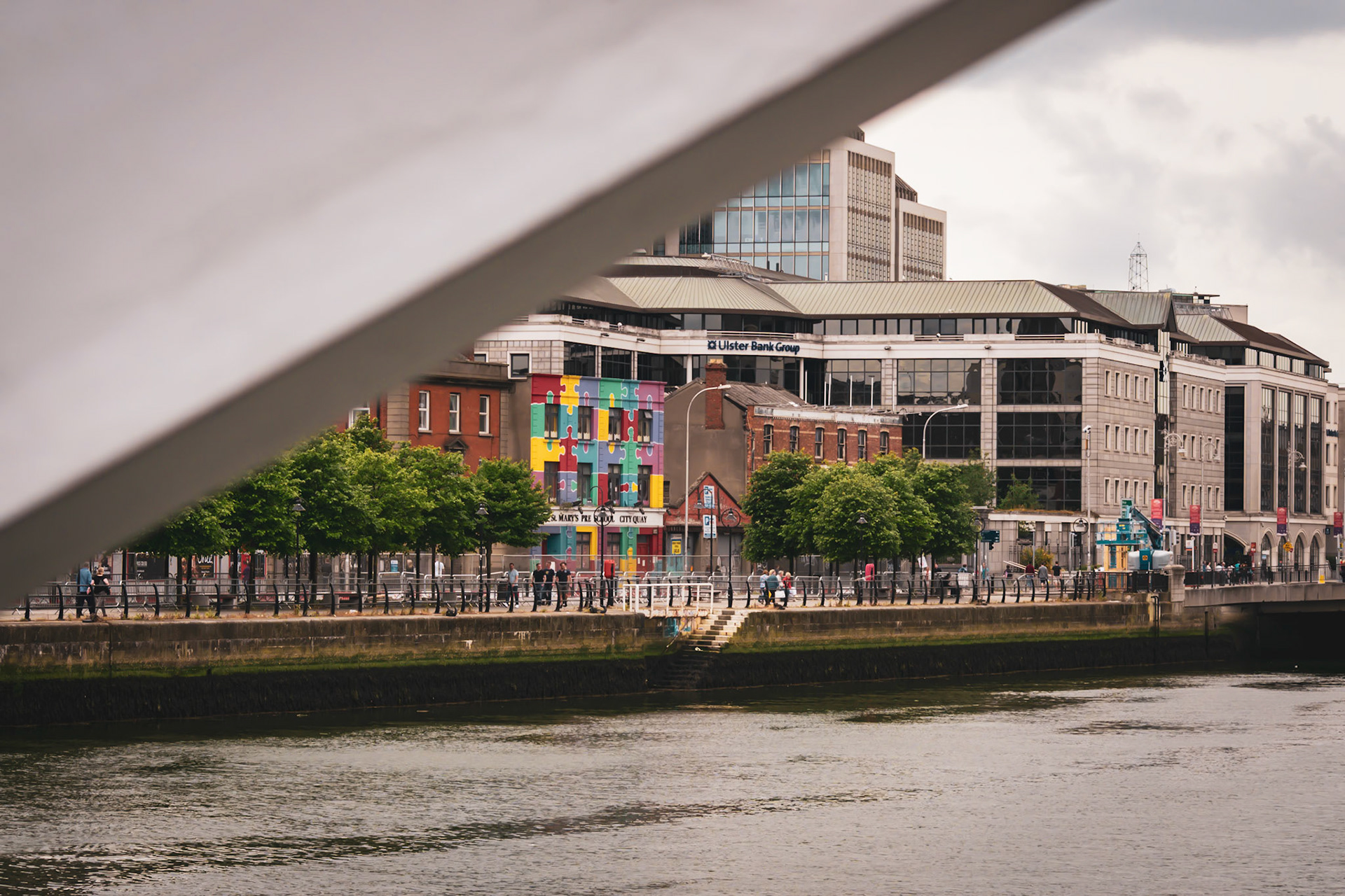 A visual look at Dublin’s maritime history, where the wooden masts and rigging of a famine ship replica stand against the modern city skyline.