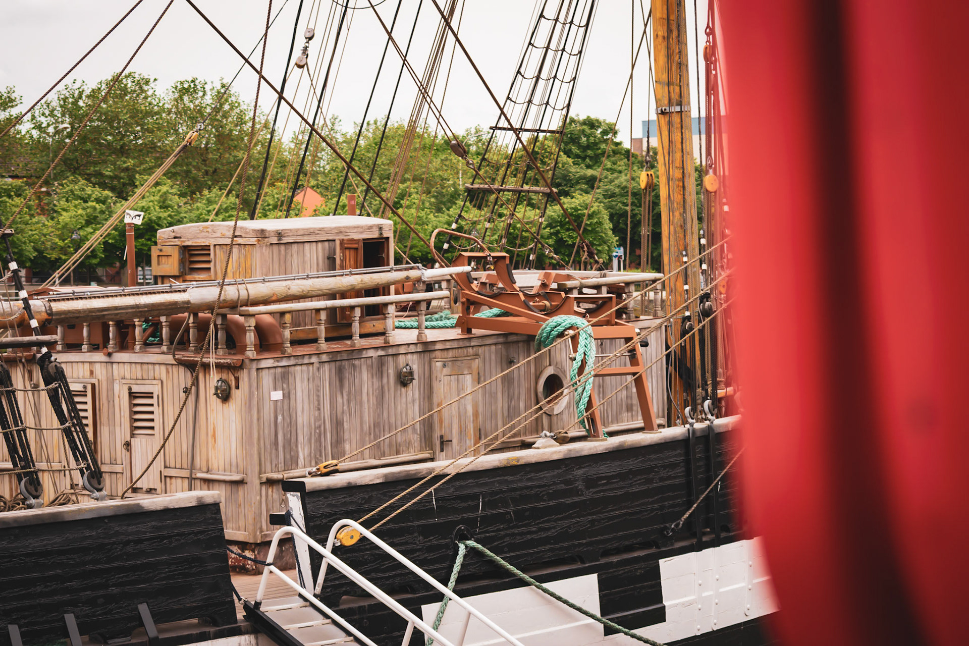 A visual look at Dublin’s maritime history, where the wooden masts and rigging of a famine ship replica stand against the modern city skyline.