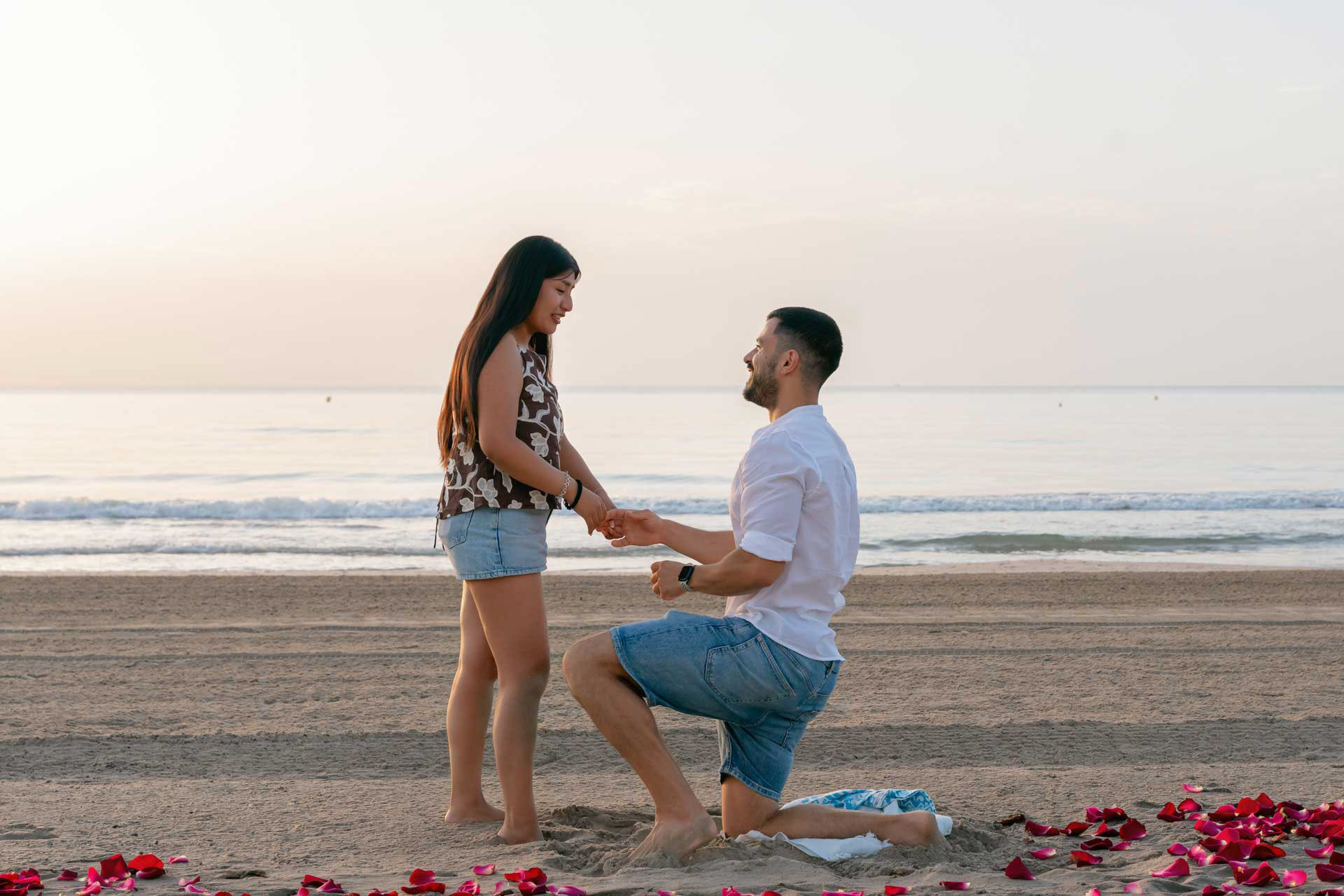  Sergio y Ana abrazados en la playa de San Juan en Alicante tras la pedida de mano sorpresa al amanecer.