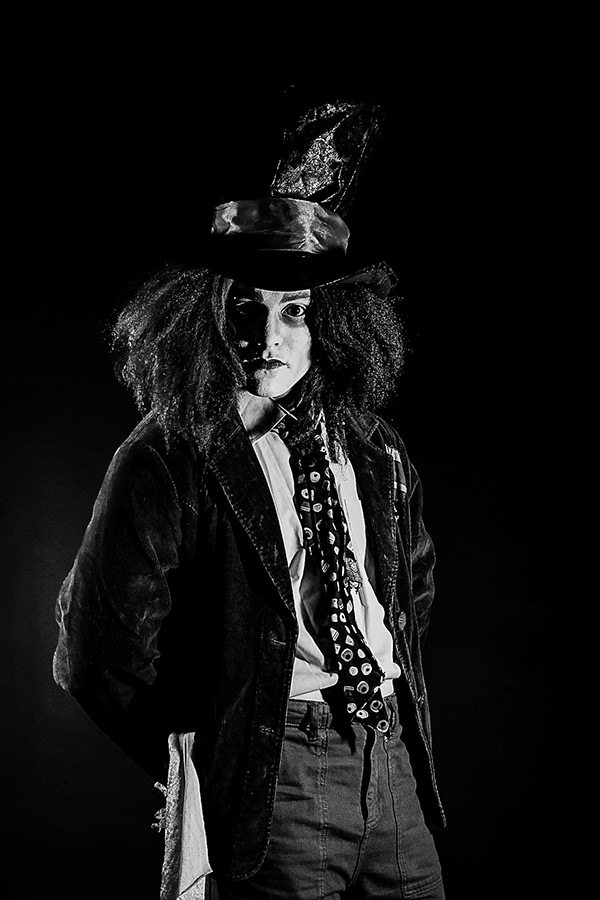 Code Red Promo Shoot - A man in white make-up with long scruffy hair and a top hat looks into the camera 