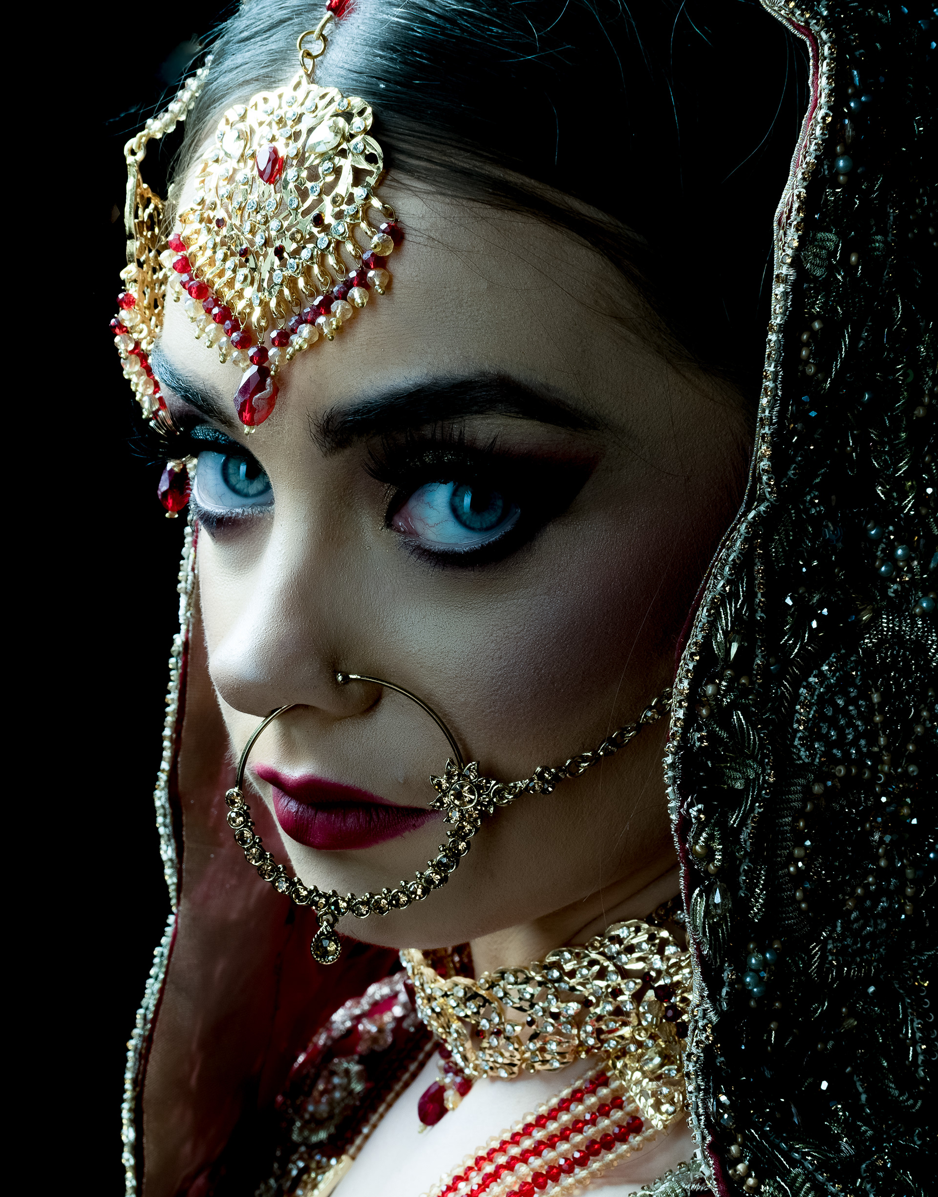 Portfolio shoot - for make- artist - A young woman wearing traditional Asian Wedding attire, looks directly at the camera 