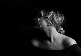 Dudley Artfest Exhibition  a young girl with her hair tied in a bun and a flower in the side by her ear, looks back over her shoulder and away from the camera