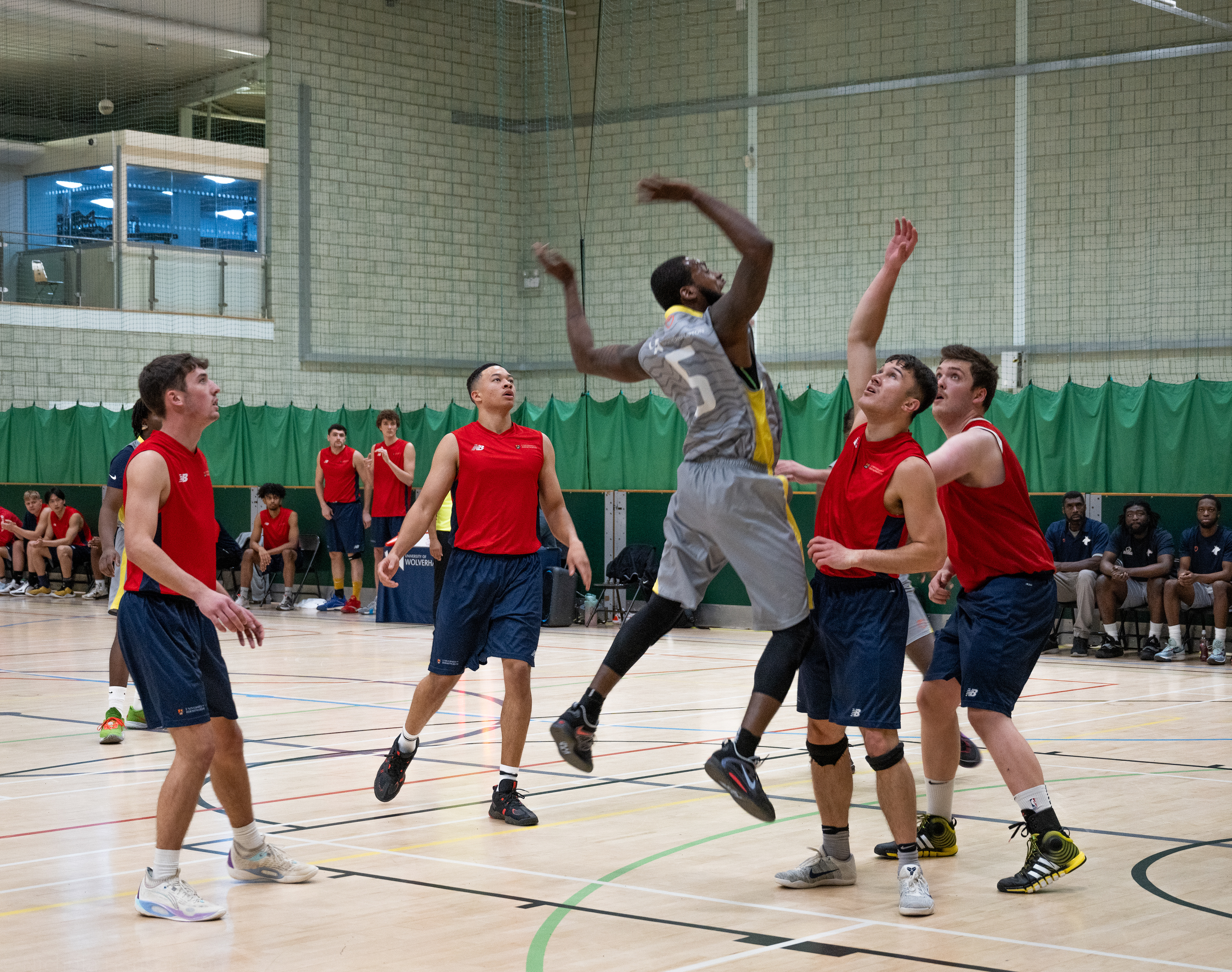 One team of basket ball payers surround a player from another team