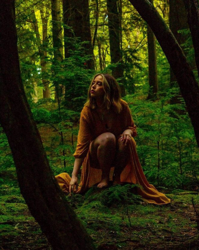 Woodland shoot Editorial - Female model dressed in a flowing dress, she is barefoot and crouched down in woodland