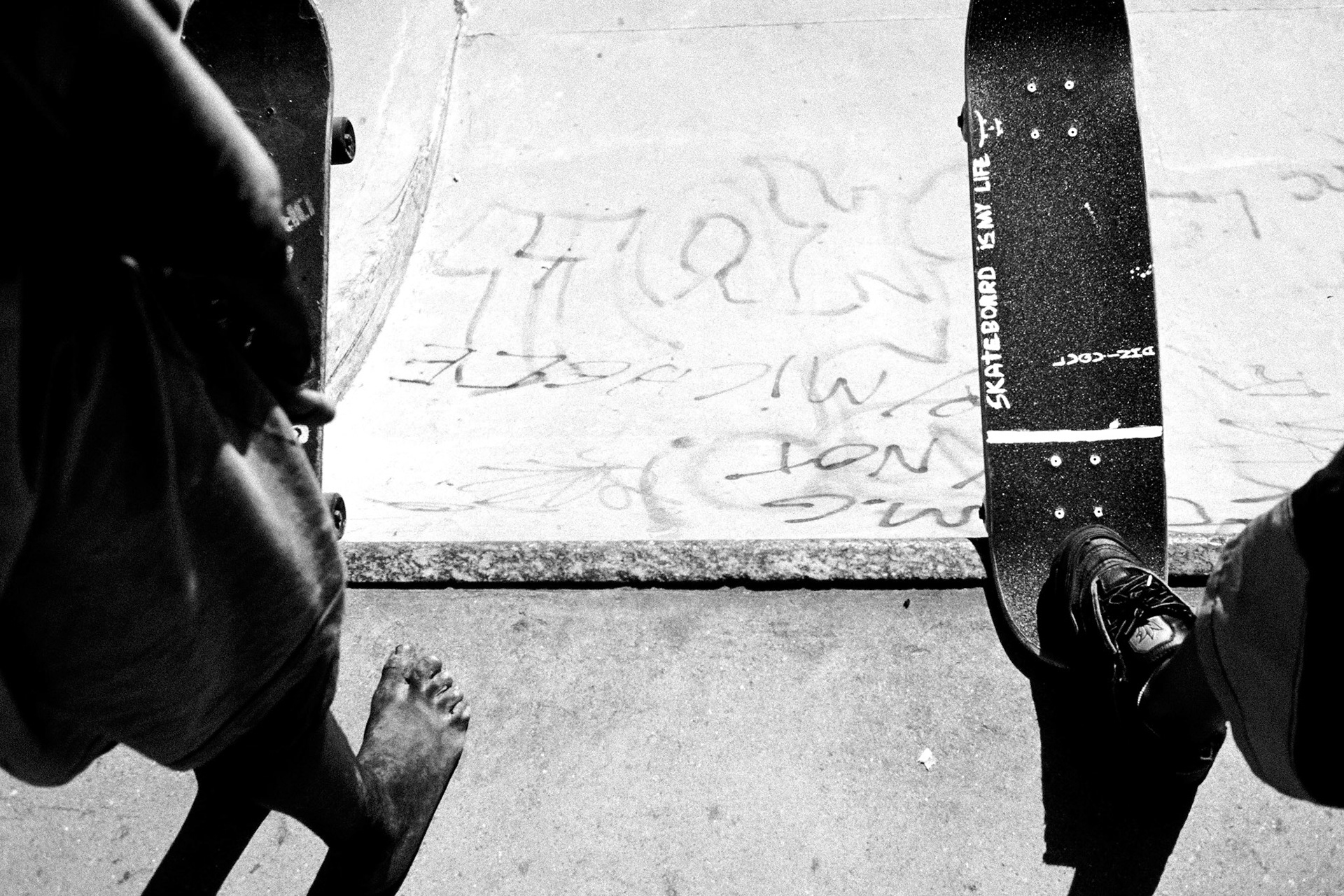 Two skaters prepare to drop in. One has bare feet and the other has 'Skateboarding is my life' written on his board.Skateboarding and Surfing in Rio de Janeiro.Rio de Janeiro, Brazil population of approx 11.5 Million. The Flamenco concrete skate park is situated near Flamenco beach and entry is free. The Lagoa skatepark is in the Ipanema area of the city. Ipanema beach is one of the most popular surf spots in the Rio area.