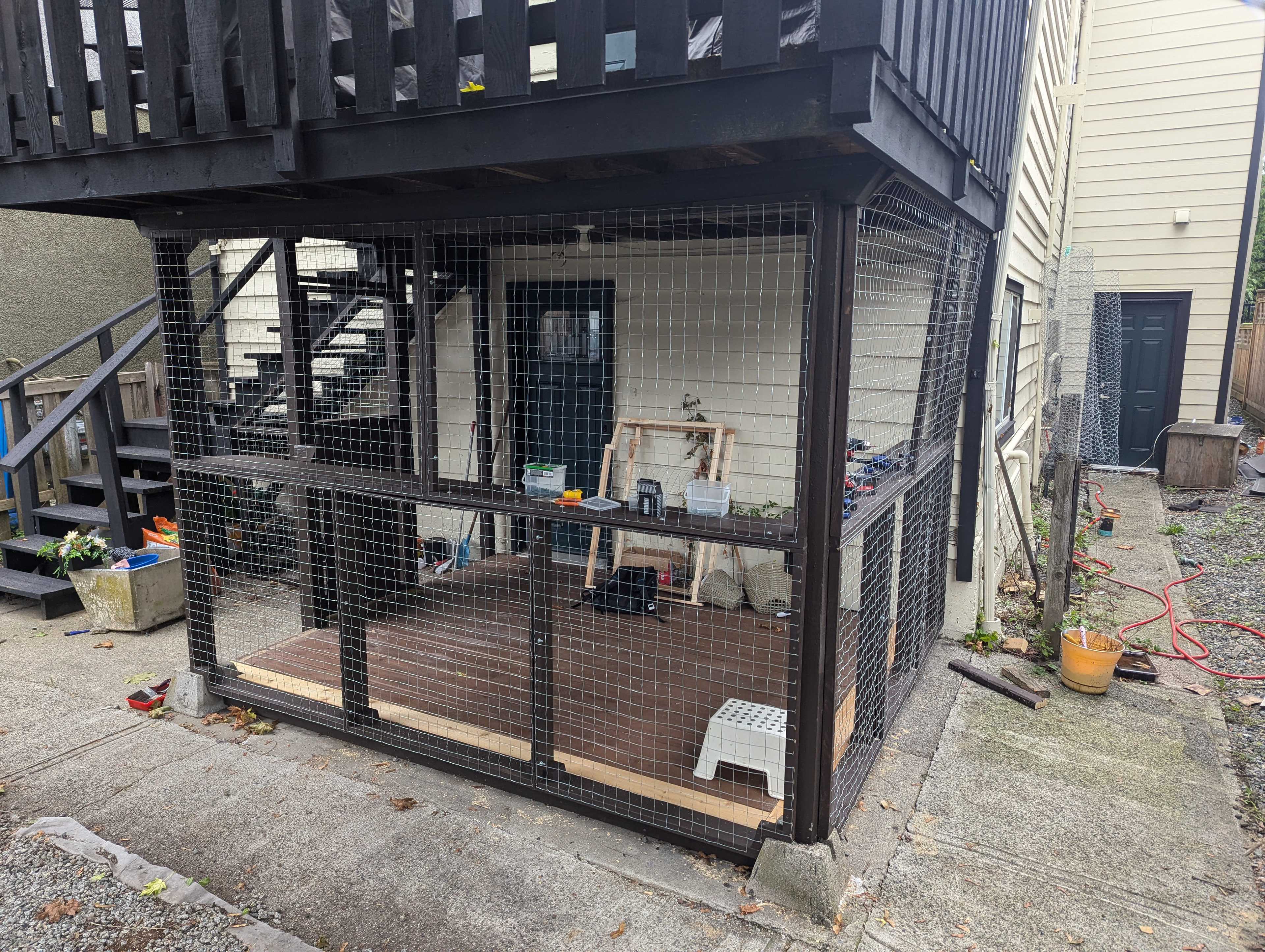 The catio will afford a measure of security on their entry door as well as giving the cats lots of space to play and lounge.