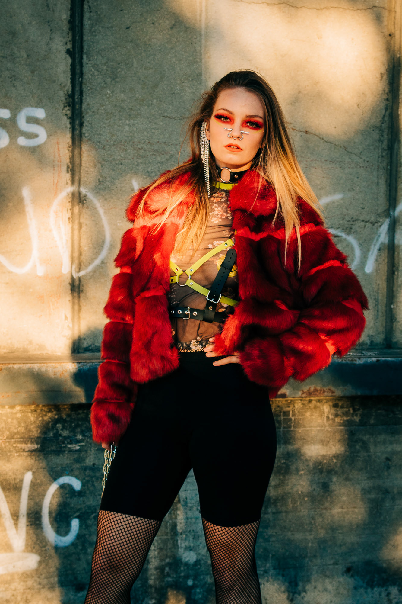 Fashion photography of a girl posing in a red fur coat