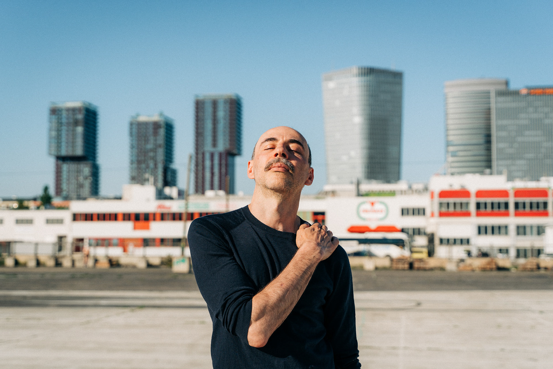 Florian Tröbinger doing a relaxed pose during a portrait shoot in a Vienna industrial area