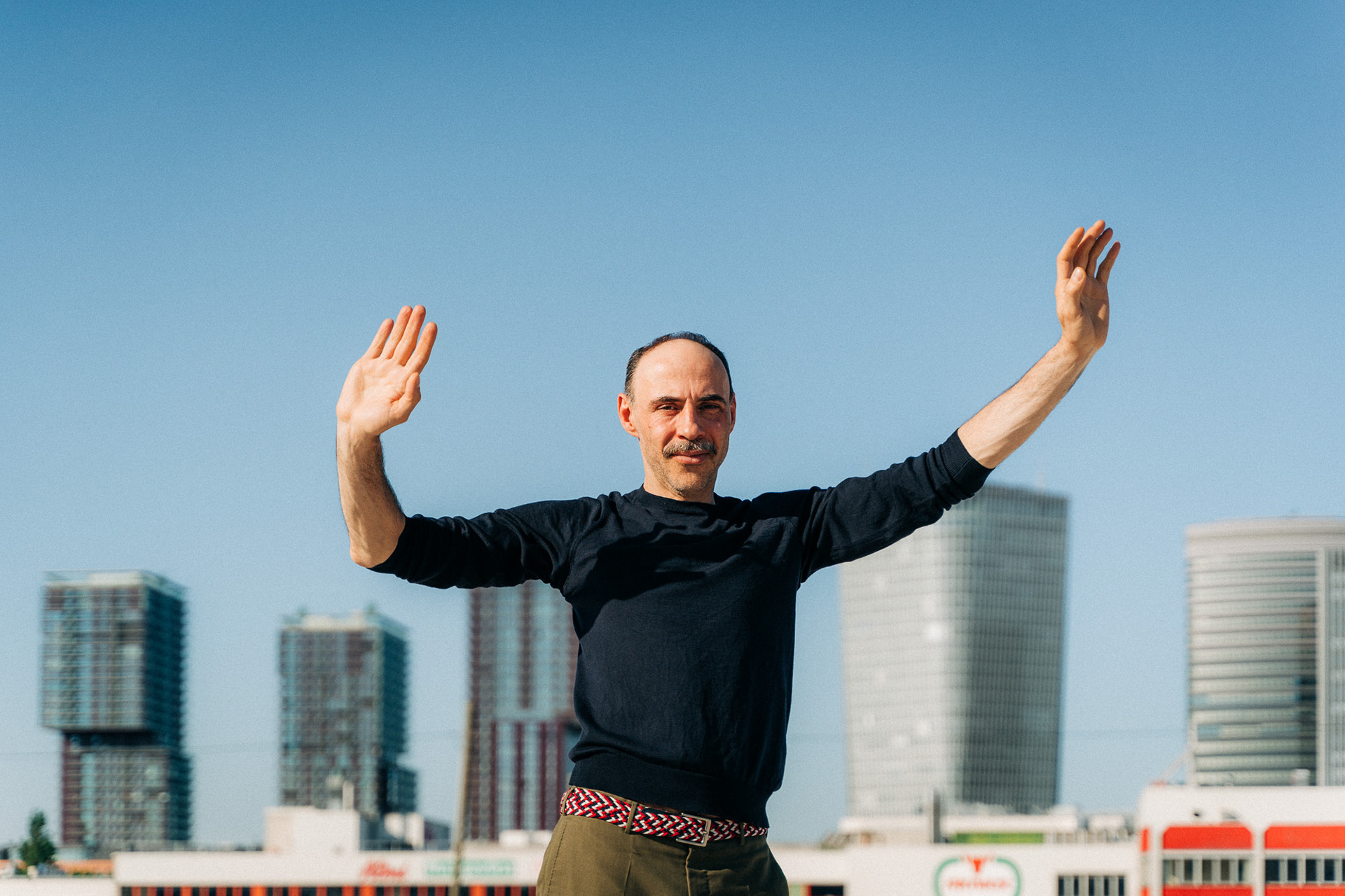 Actor Florian Tröbinger photographed posing in front of several highrise buildings