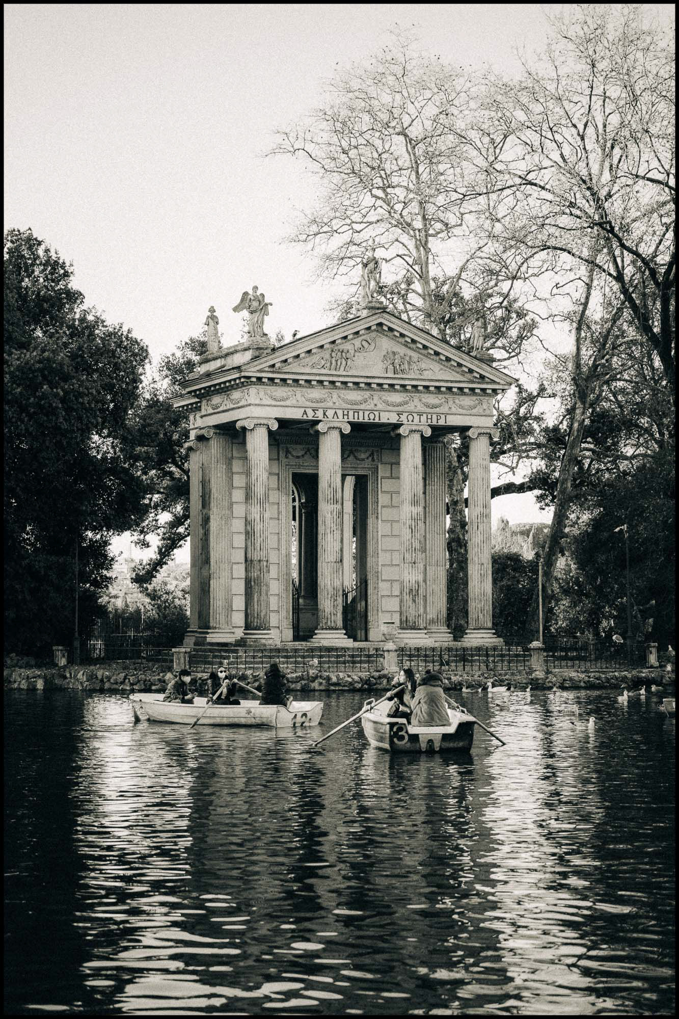 People in rowing boats in front of the Temple of Aesculapius at villa Borghese
