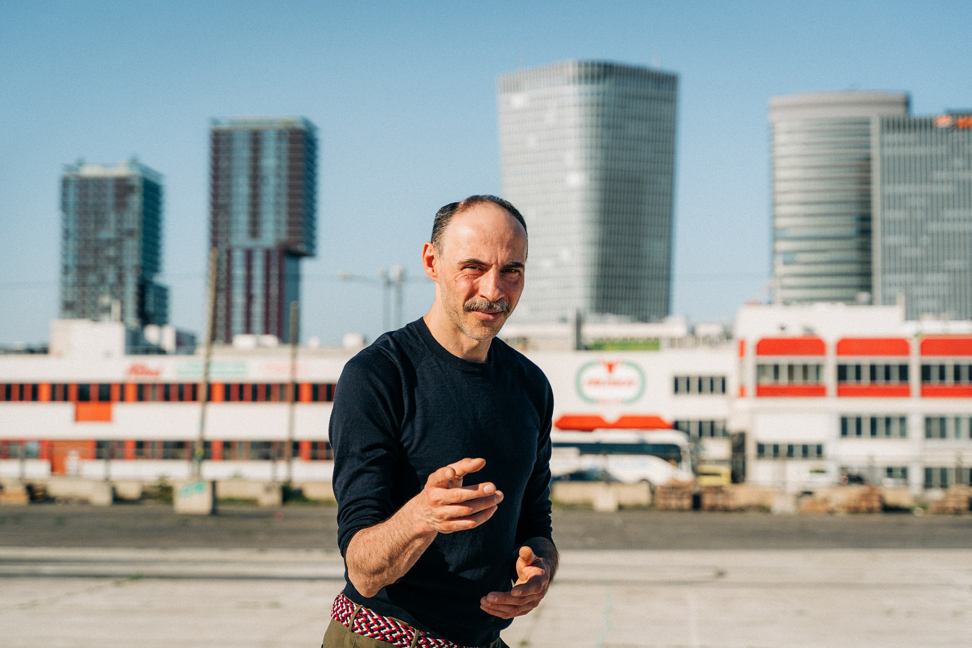 Actor Florian Tröbinger photographed in an urban setting pointing his hand in direction of the camera