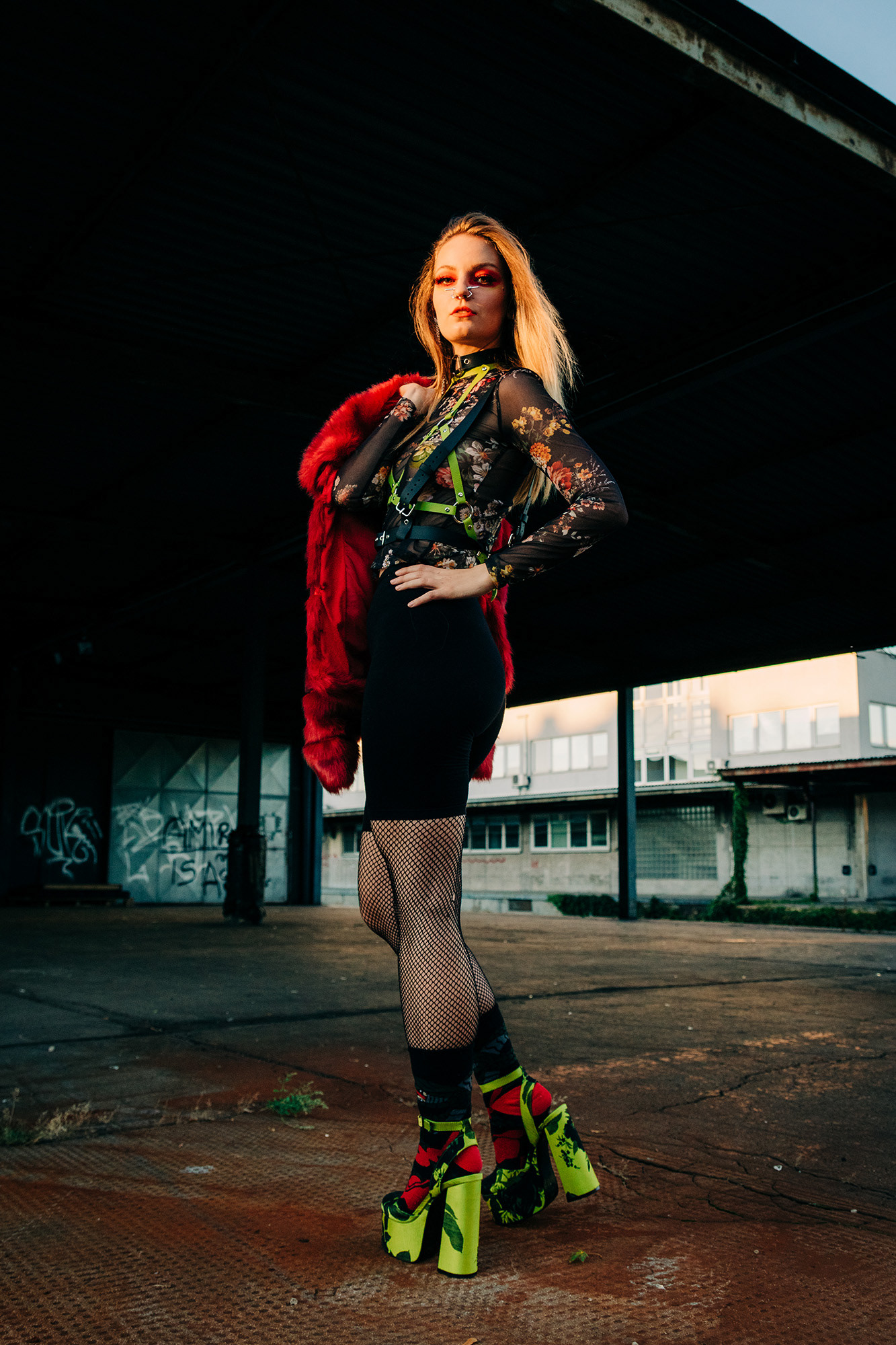 Young woman posing for a fashion shoot in an industrial area as the golden hour light shines on her face and hair