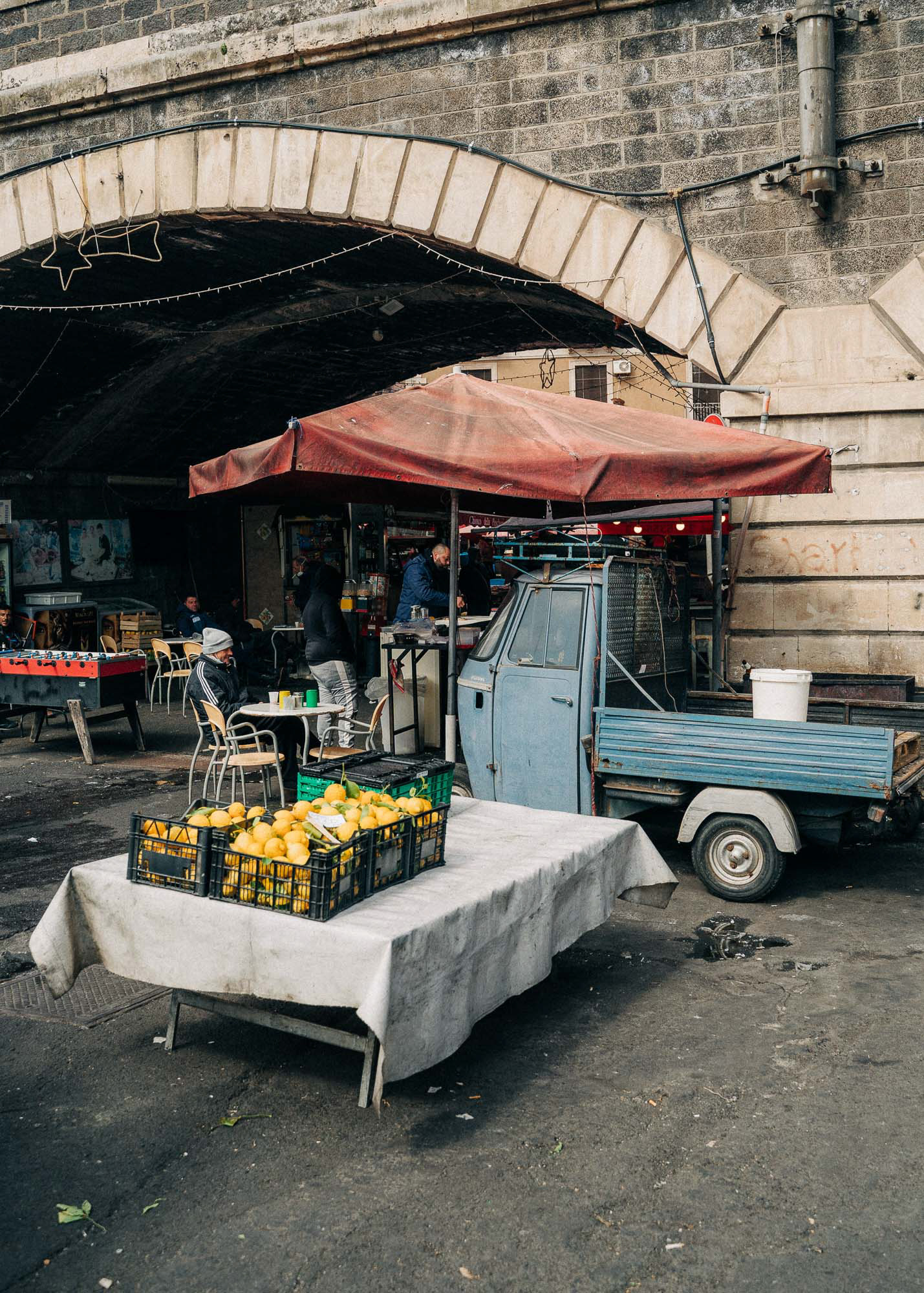 Fresh lemon in crates on a table in front of a blue 
