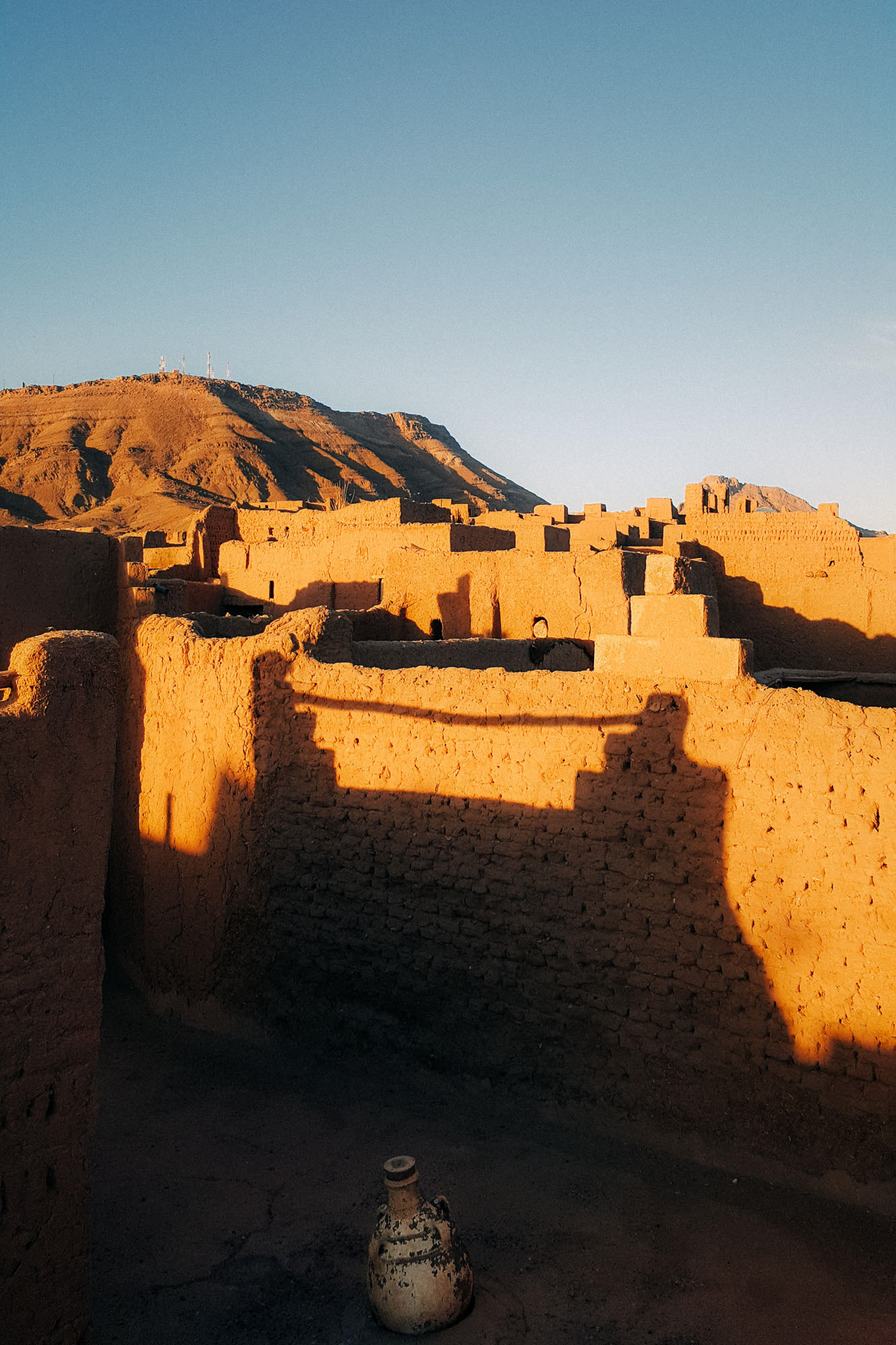 The sunset casting shadows and golden light over clay huts in Zagora