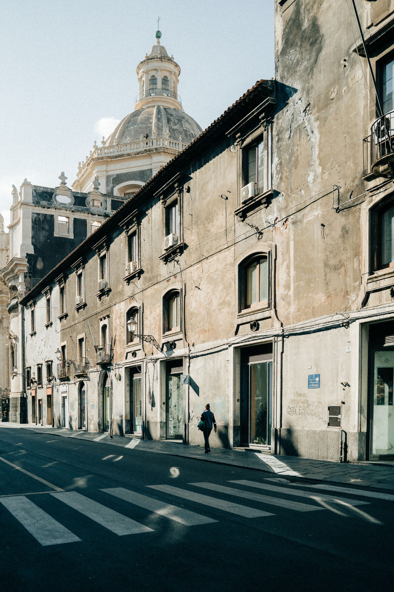 Travel photography showing a street in Catania with a single person walking