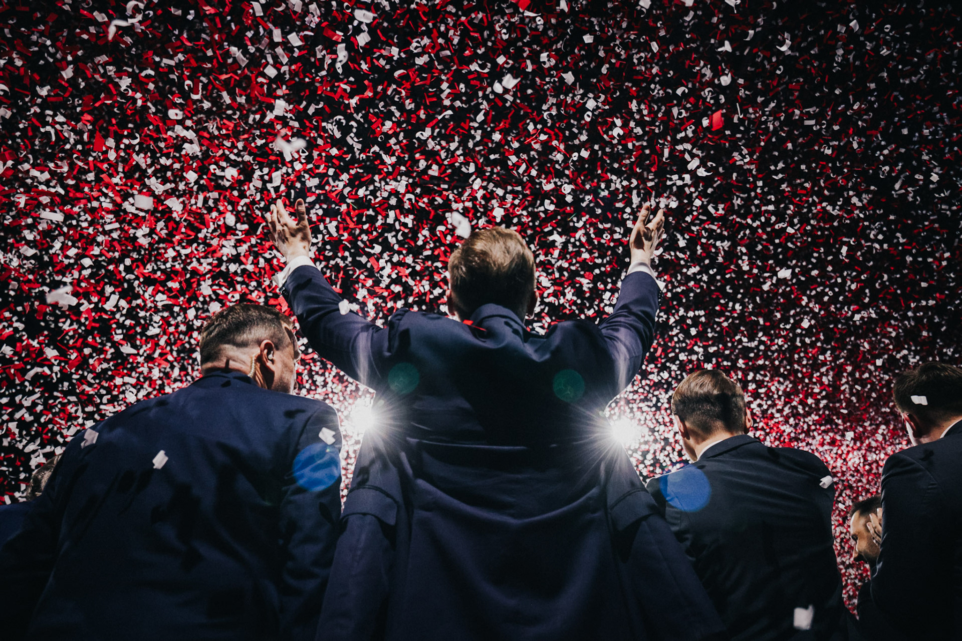 Politicians on stage amid a cascade of red-and-white confetti, marking the climax of the election convention.