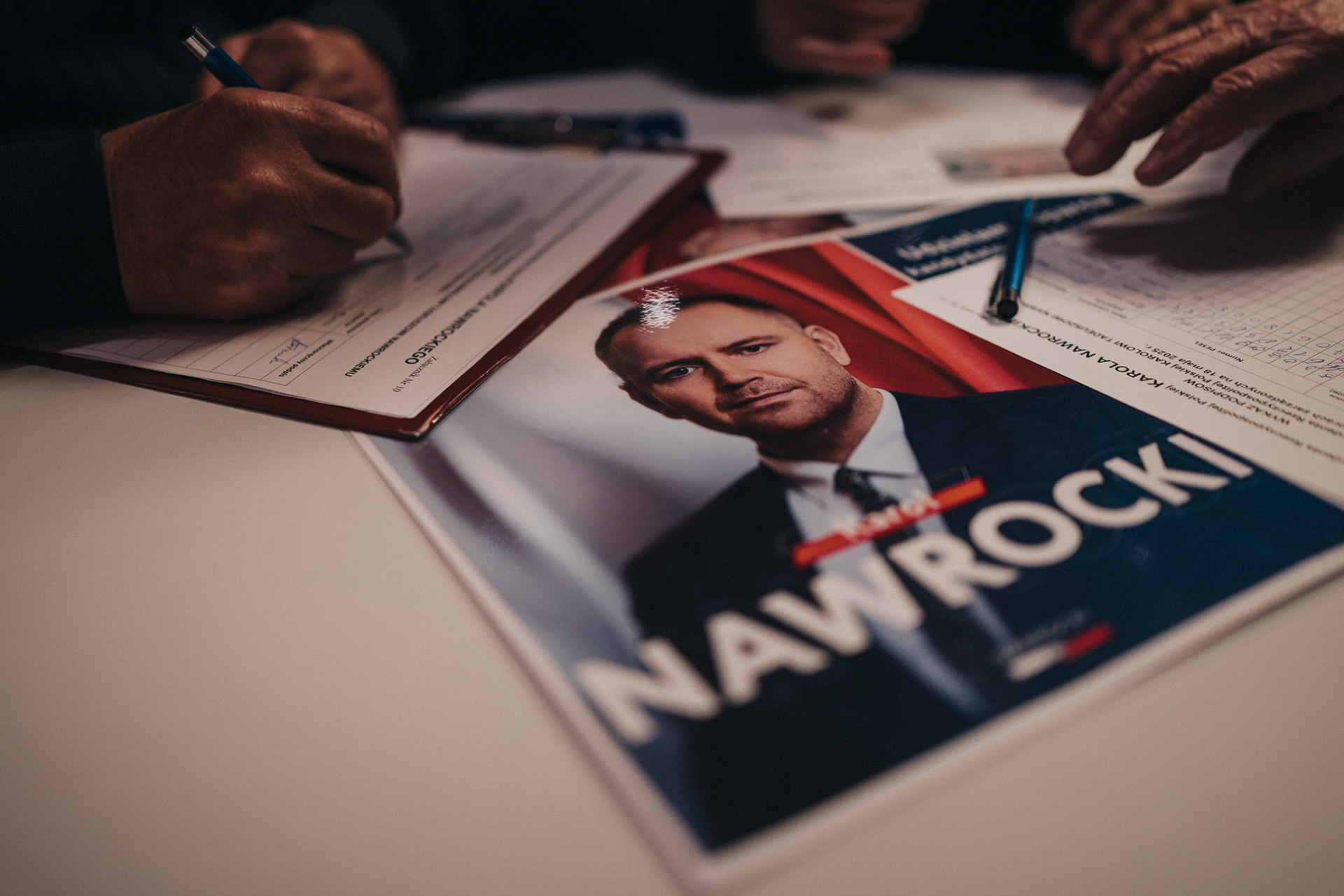 Local residents sign support forms for Karol Nawrocki during an election meeting.
