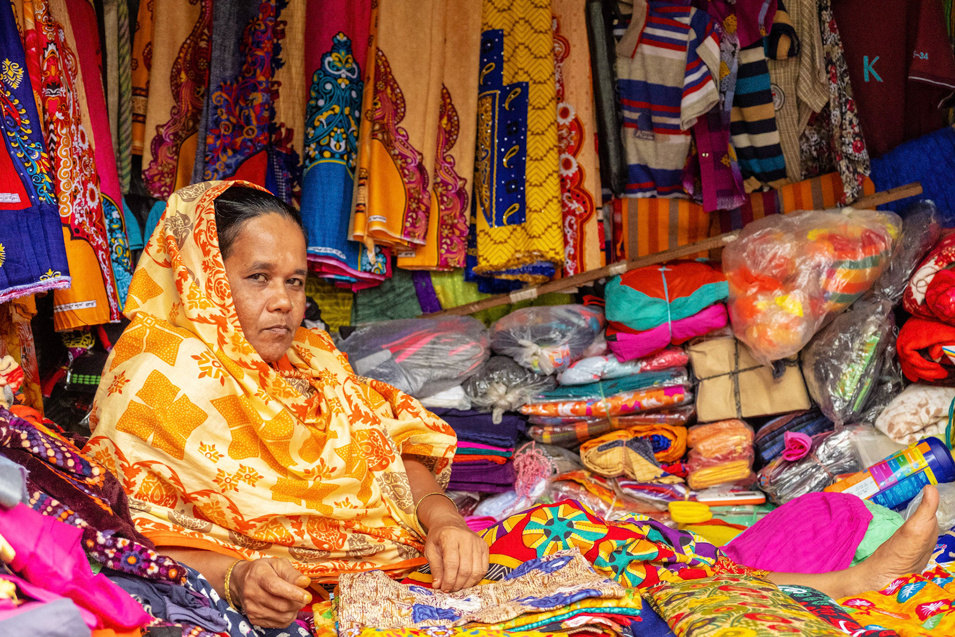 Woman selling colorful fabric in a street market