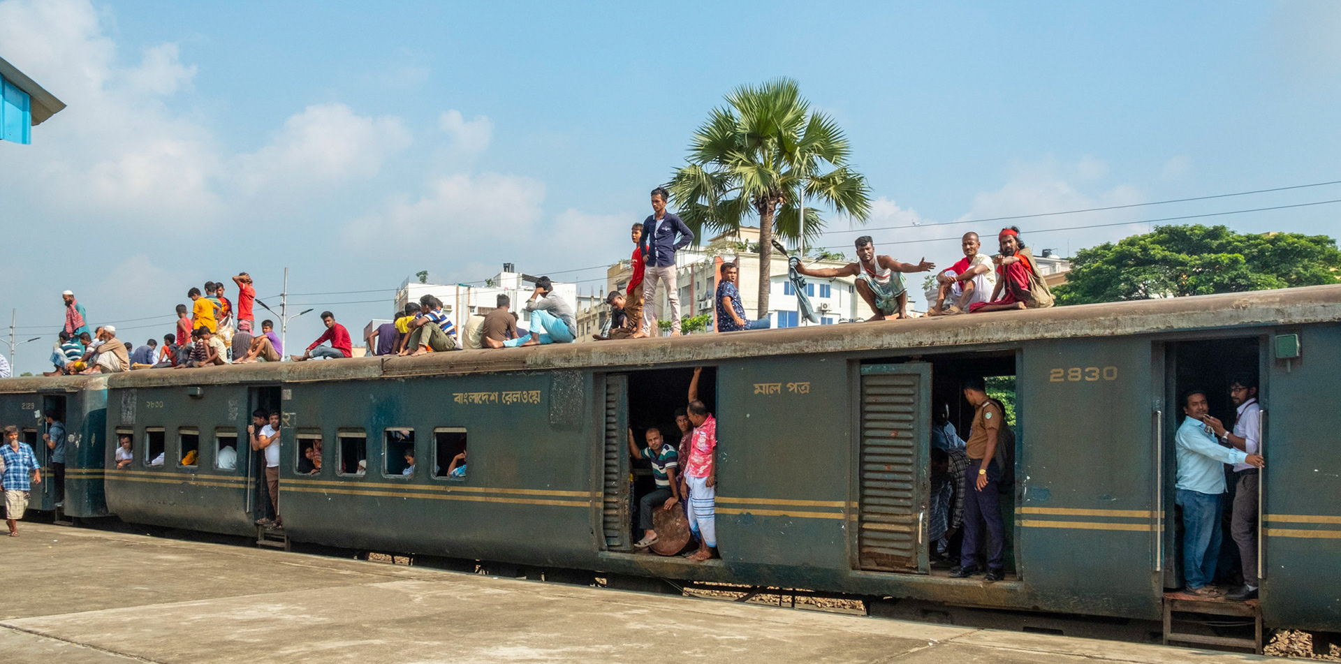 Locals ride on the top of crowded trains to save money