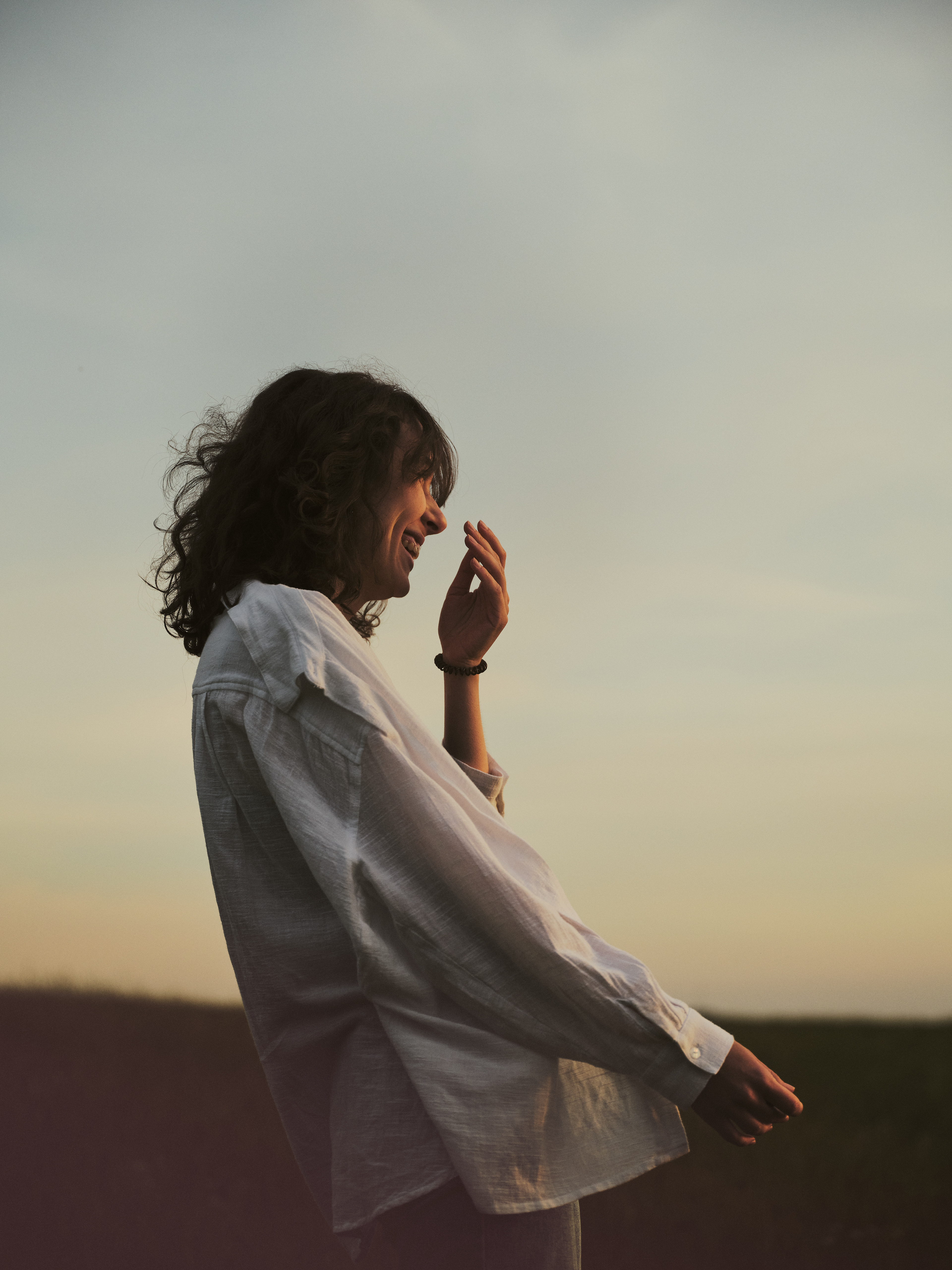 Fotoshooting Dörnberg bei Sonnenuntergang. Portrait mit glücklicher Frau in weißem Leinenhemd. Bildstil von Fotograf Alexander Groß
