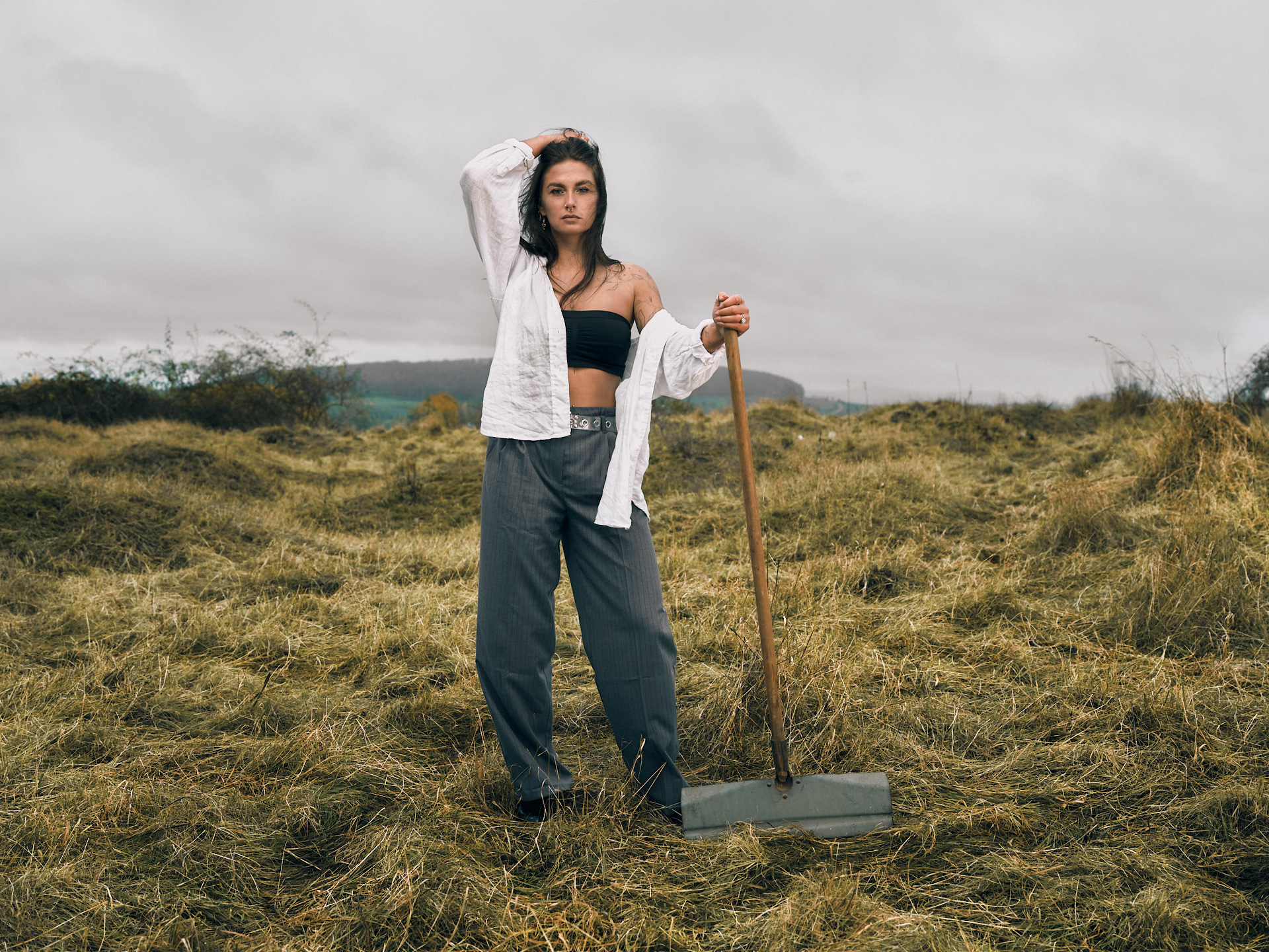 Modefotoshooting in Kassel und Warburg bei bewölktem Wetter mit einer Frau in weißem Leinenhemd und schwarzen Haaren die in Wind wehen. Annika Spellerberg als Modell und Alexander Groß als Fotograf 
