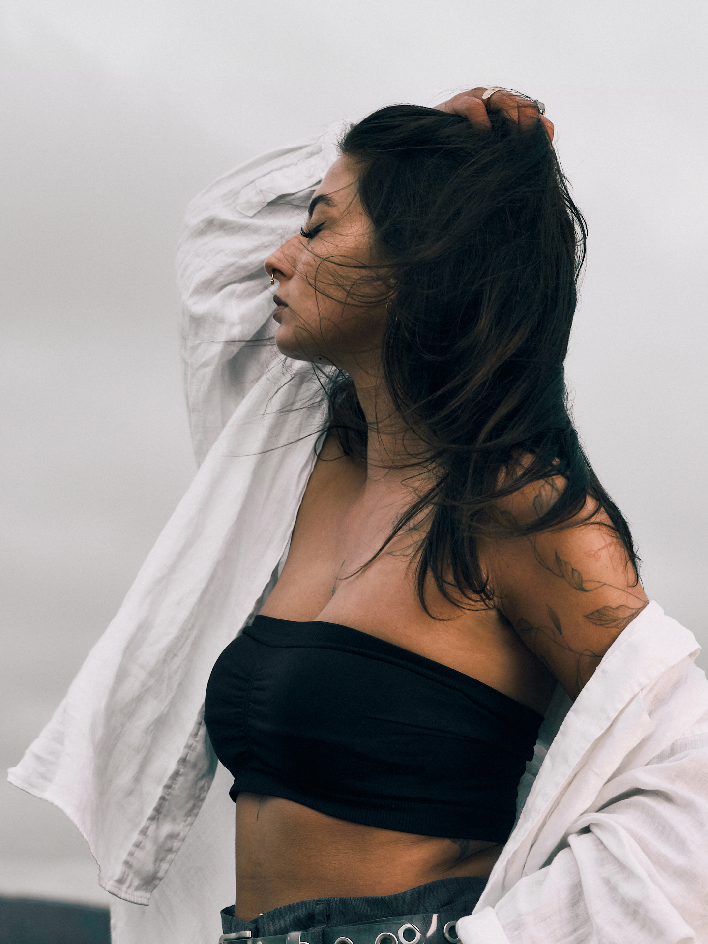 Modefotoshooting in Kassel und Warburg bei bewölktem Wetter mit einer Frau in weißem Leinenhemd und schwarzen Haaren die in Wind wehen. Annika Spellerberg als Modell und Alexander Groß als Fotograf 