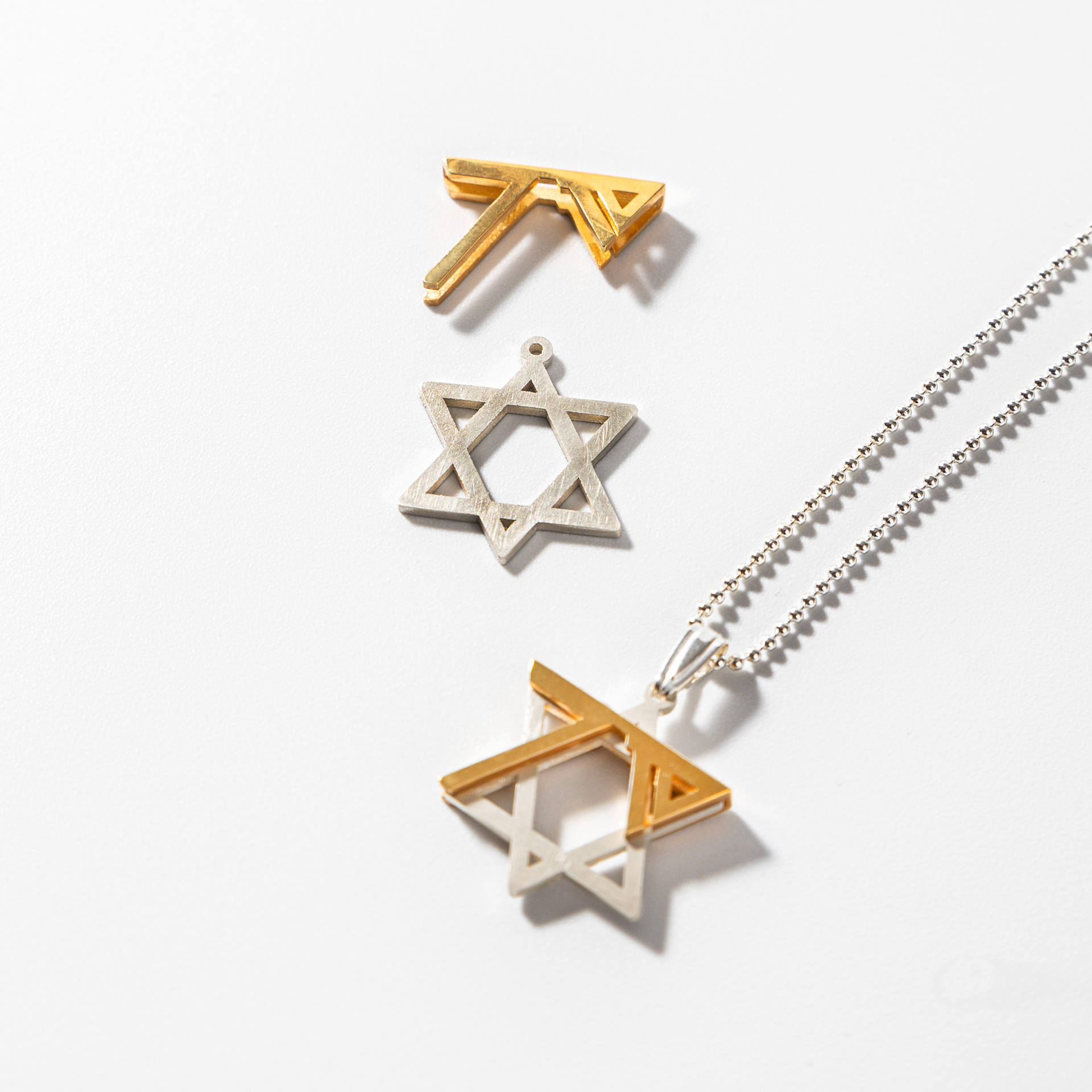 A pendant in two parts designed by Ahava Rahminov, the first part of the pendant is a Star of David and the second part indicates the date of the beginning of the war in Israel 7.10.