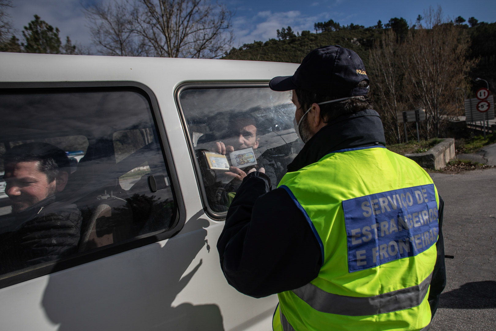 Un agente de fronteras portugúes pide la documentación a los ocupantes de un vehículo en la frontera de Quintanilha.