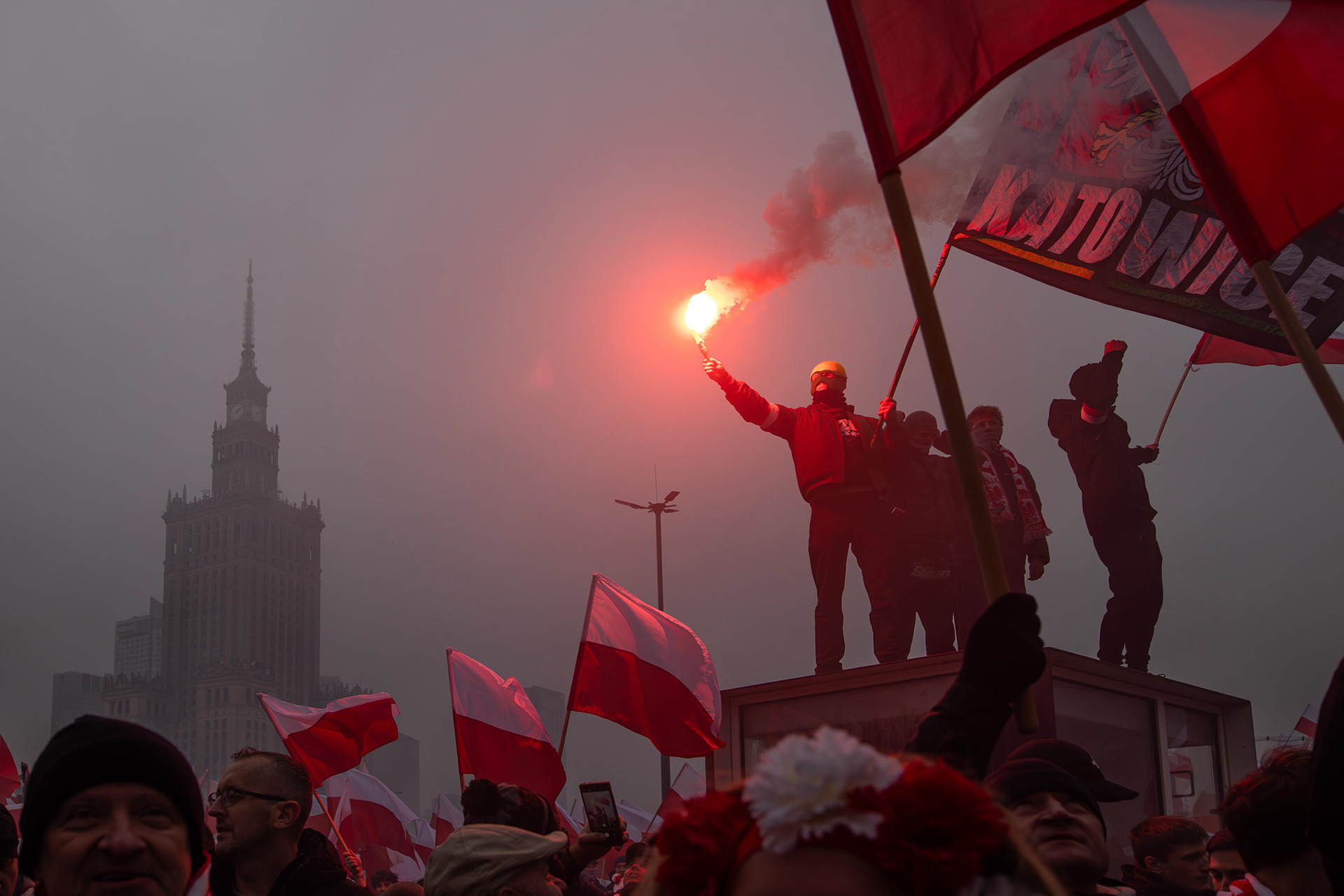 Football fans light flares at a tram stop during the “W Hour” commemorations in Warsaw. Photo © Marek Ladzinski