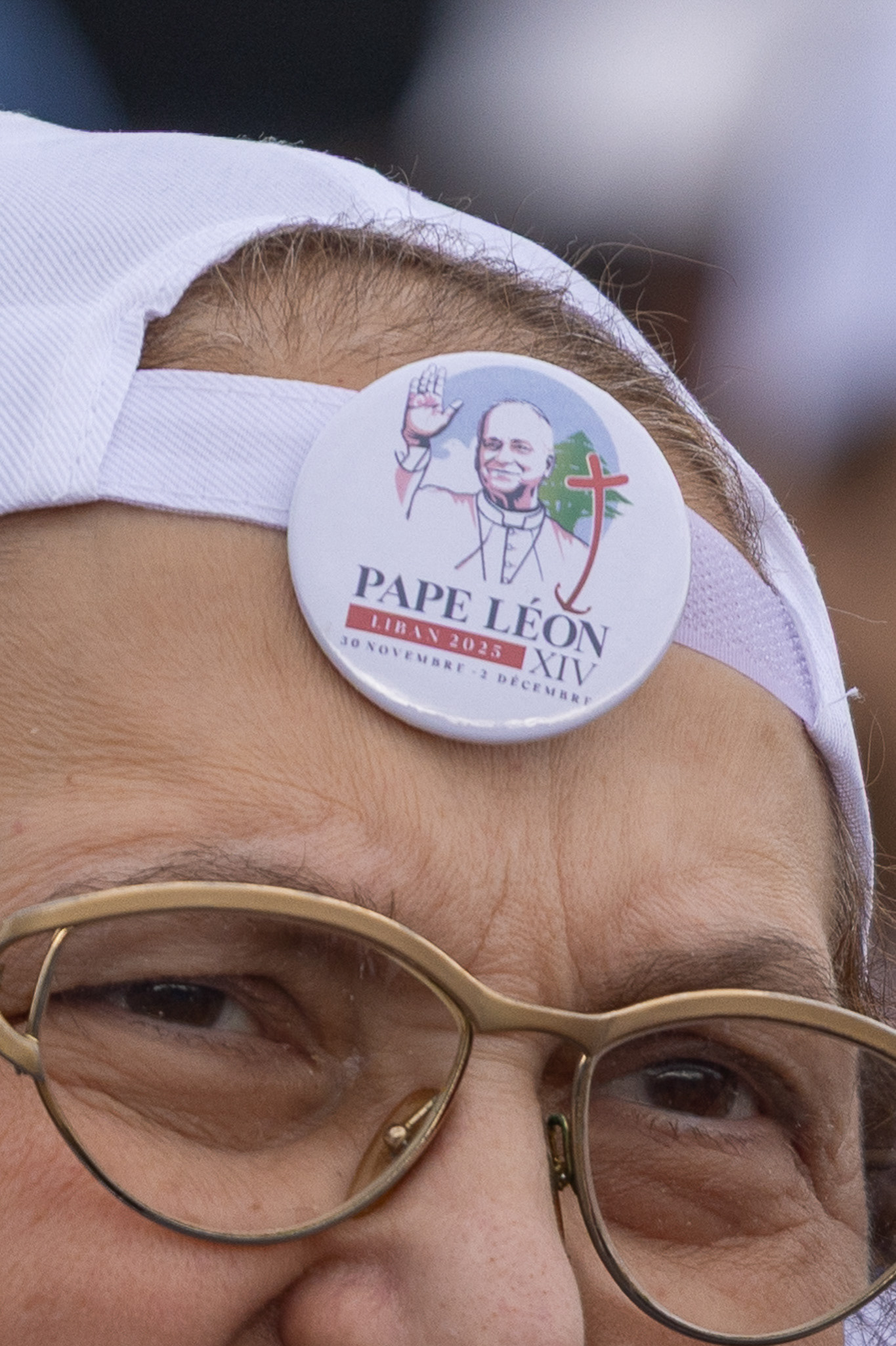 Attendees at the Mass wear badges featuring the image of Pope Leo XIV, expressing their joy at his visit and participation in the liturgy in Beirut. Photo by: © Marek Ladzinski/ZUMA Press Wire