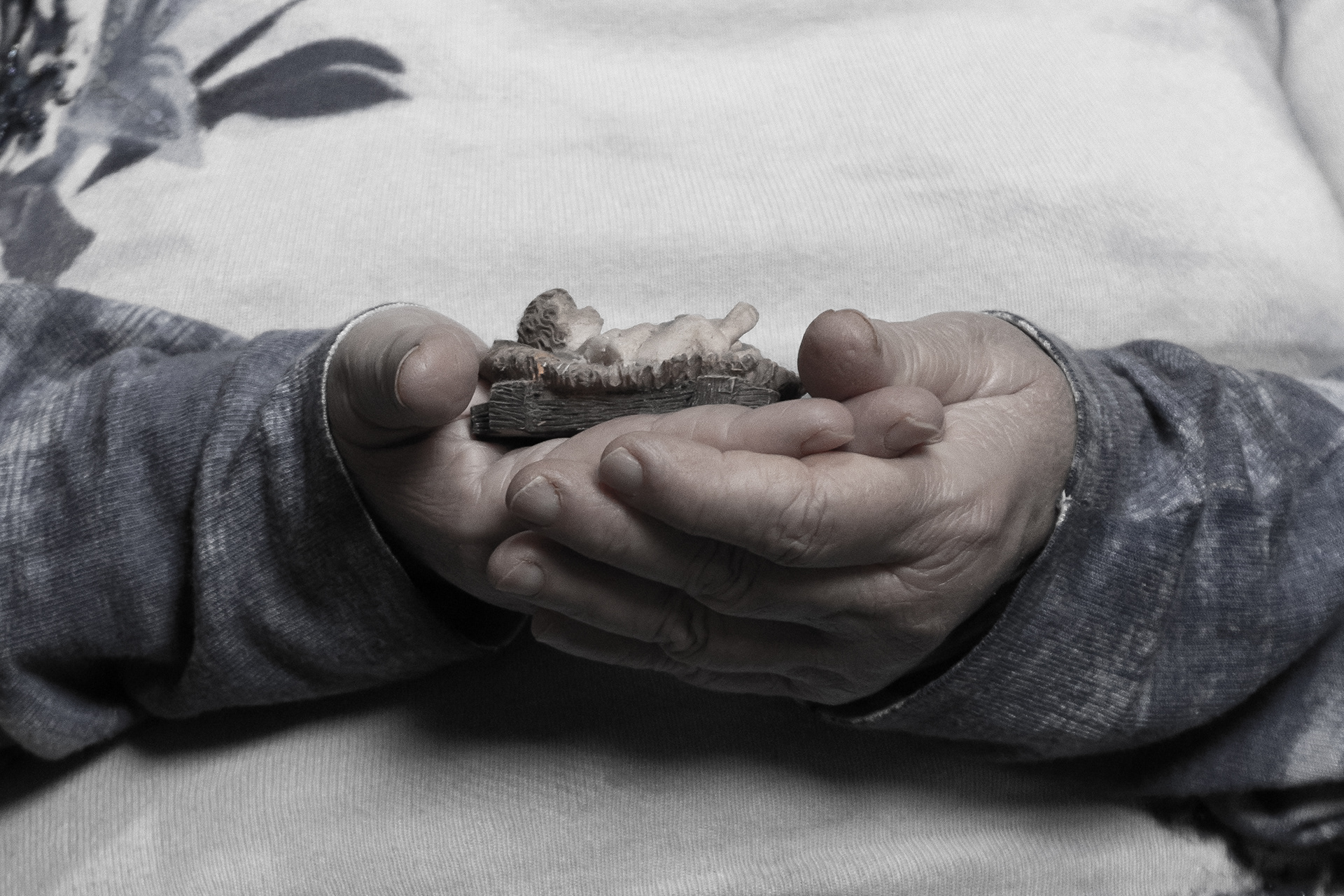 Fatima holds a small figurine of Christ, symbolizing hope and spiritual support. Photo © Marek Ladzinski.