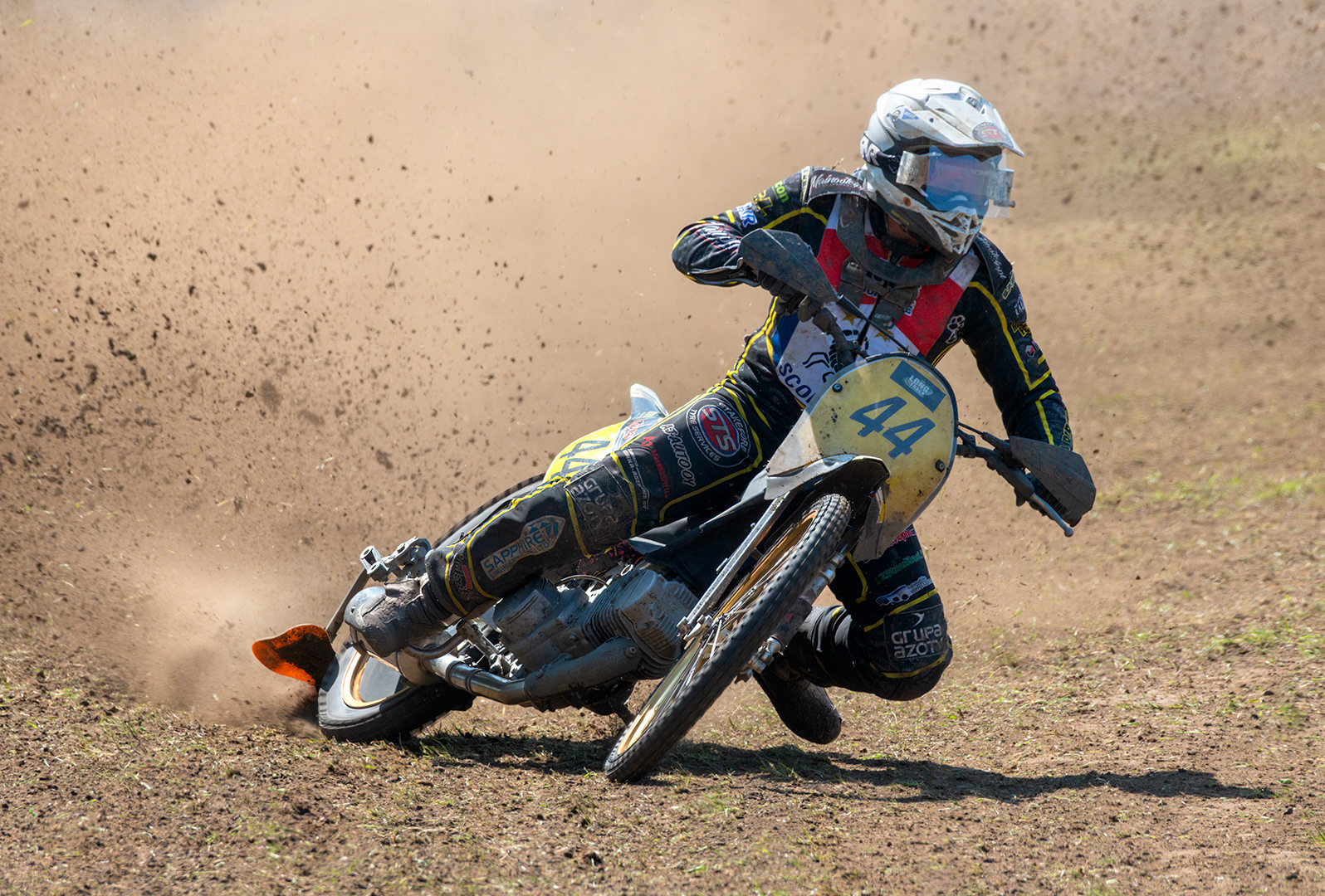 Motorcyclist turning a corner during a grasstrack race
