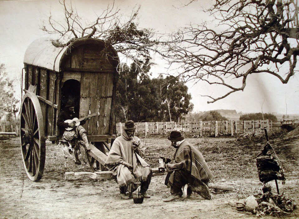 Gauchos argentini bevono mate e suonano la chitarra nella Pampa. Anno 1890.