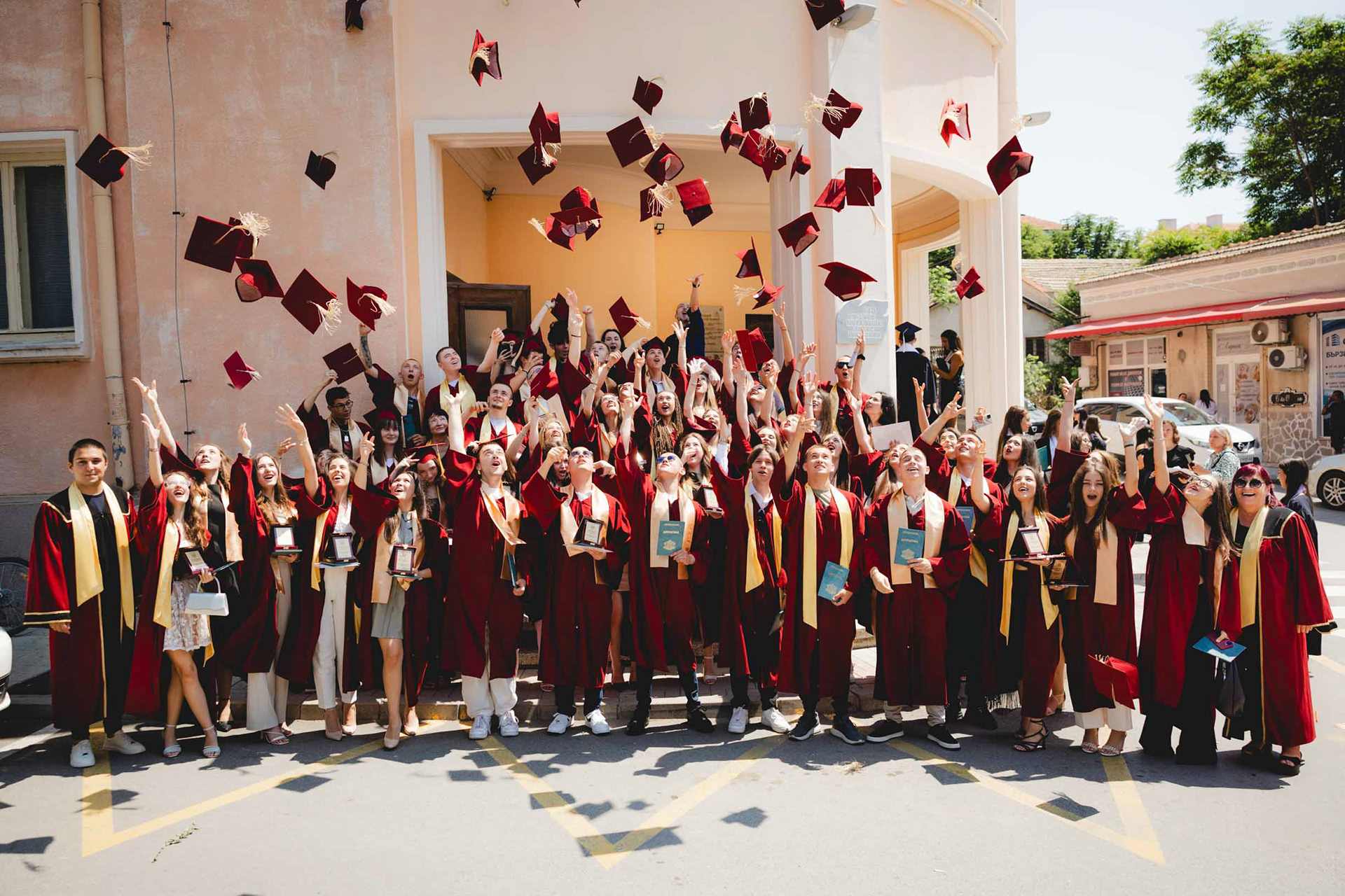 Фотограф за завършване. Емоционален момент на зрелостници с тогите.